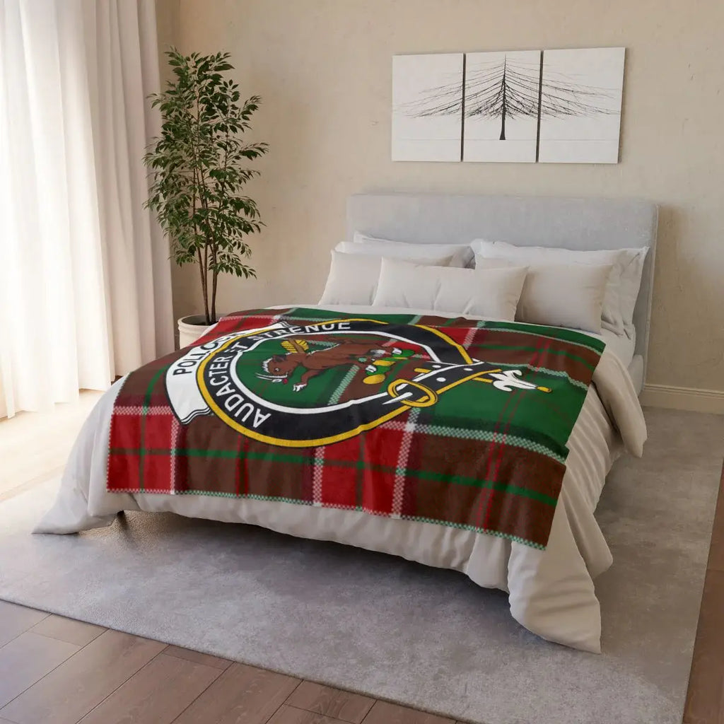 Pollock clan crest tartan throw draped on sofa — printed design, white reverse, hemmed edges