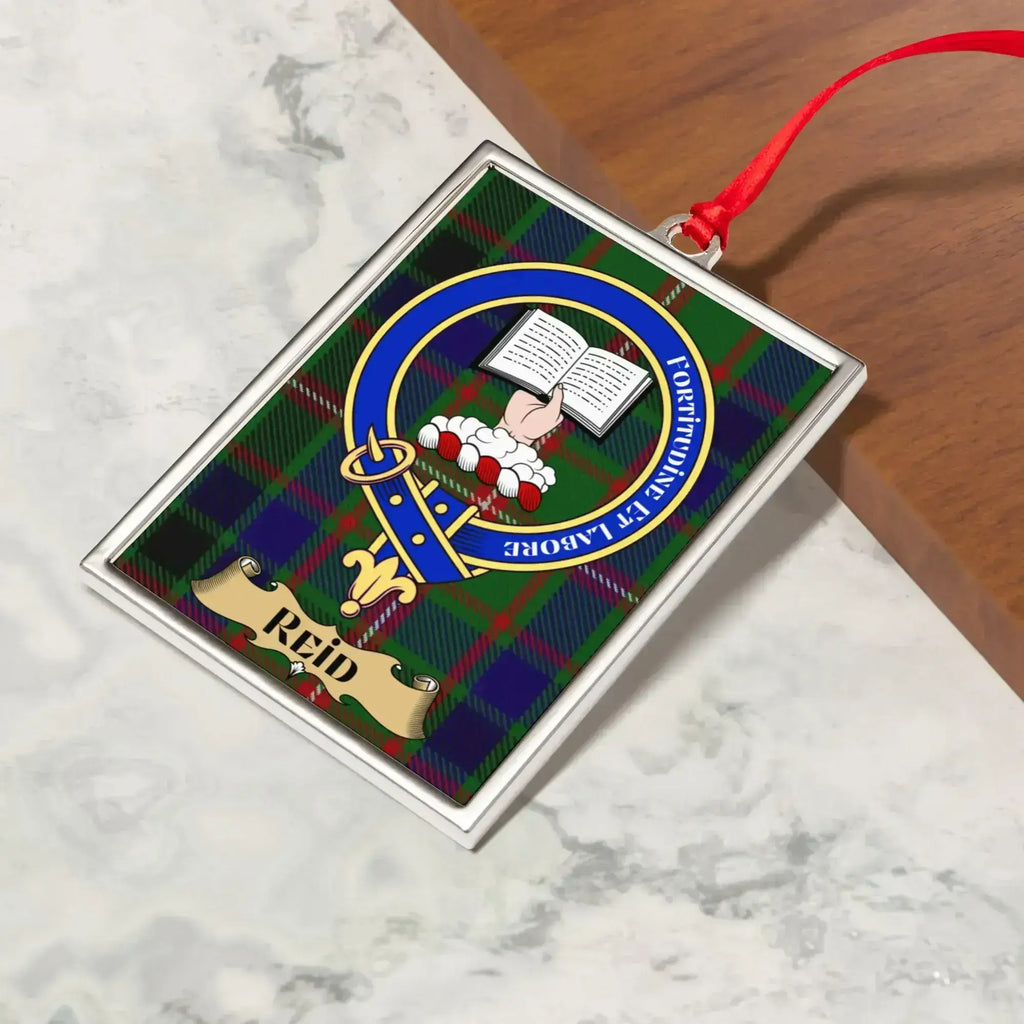 Reid ornament hanging from a Christmas tree branch by its satin ribbon
