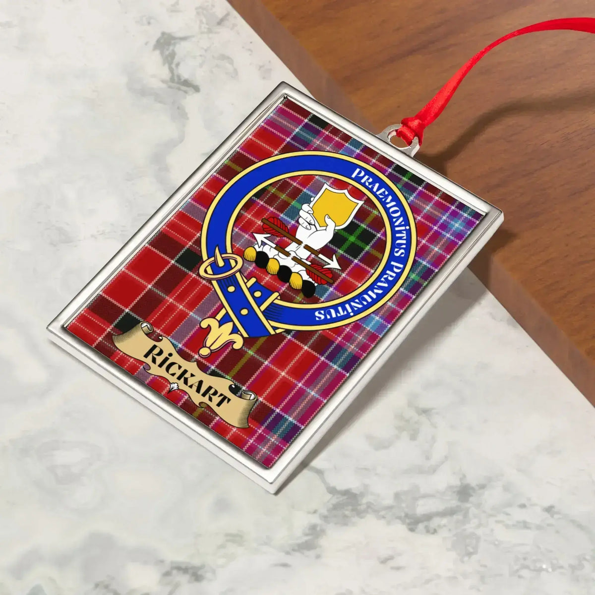 Rickart ornament hanging from a Christmas tree branch by its satin ribbon