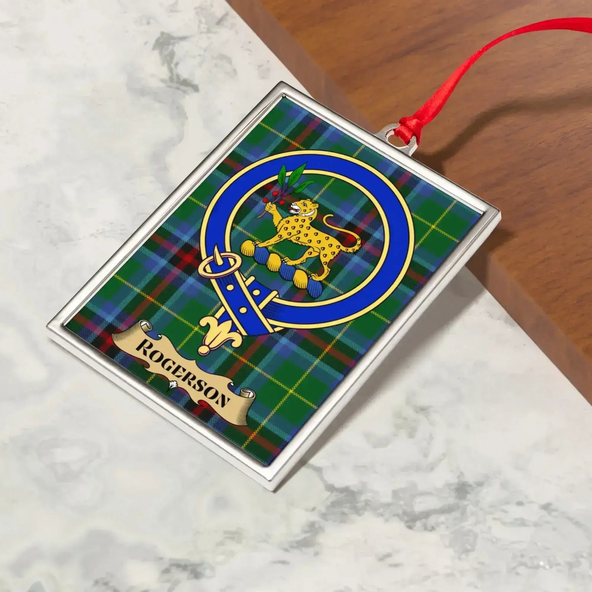 Rogerson ornament hanging from a Christmas tree branch by its satin ribbon