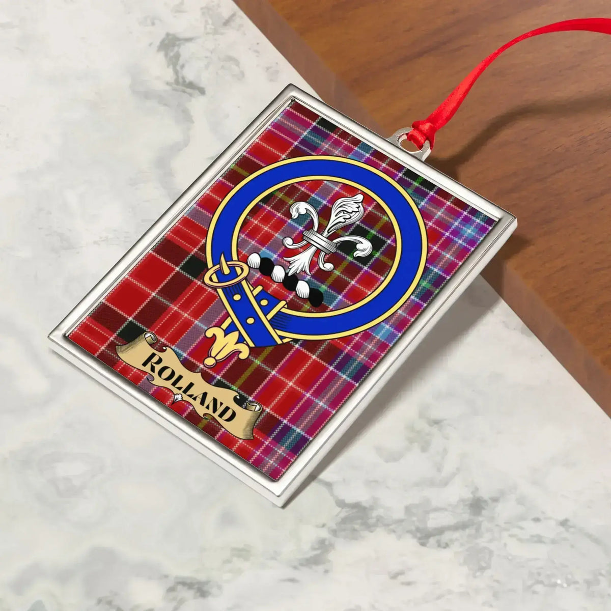 Rolland ornament hanging from a Christmas tree branch by its satin ribbon