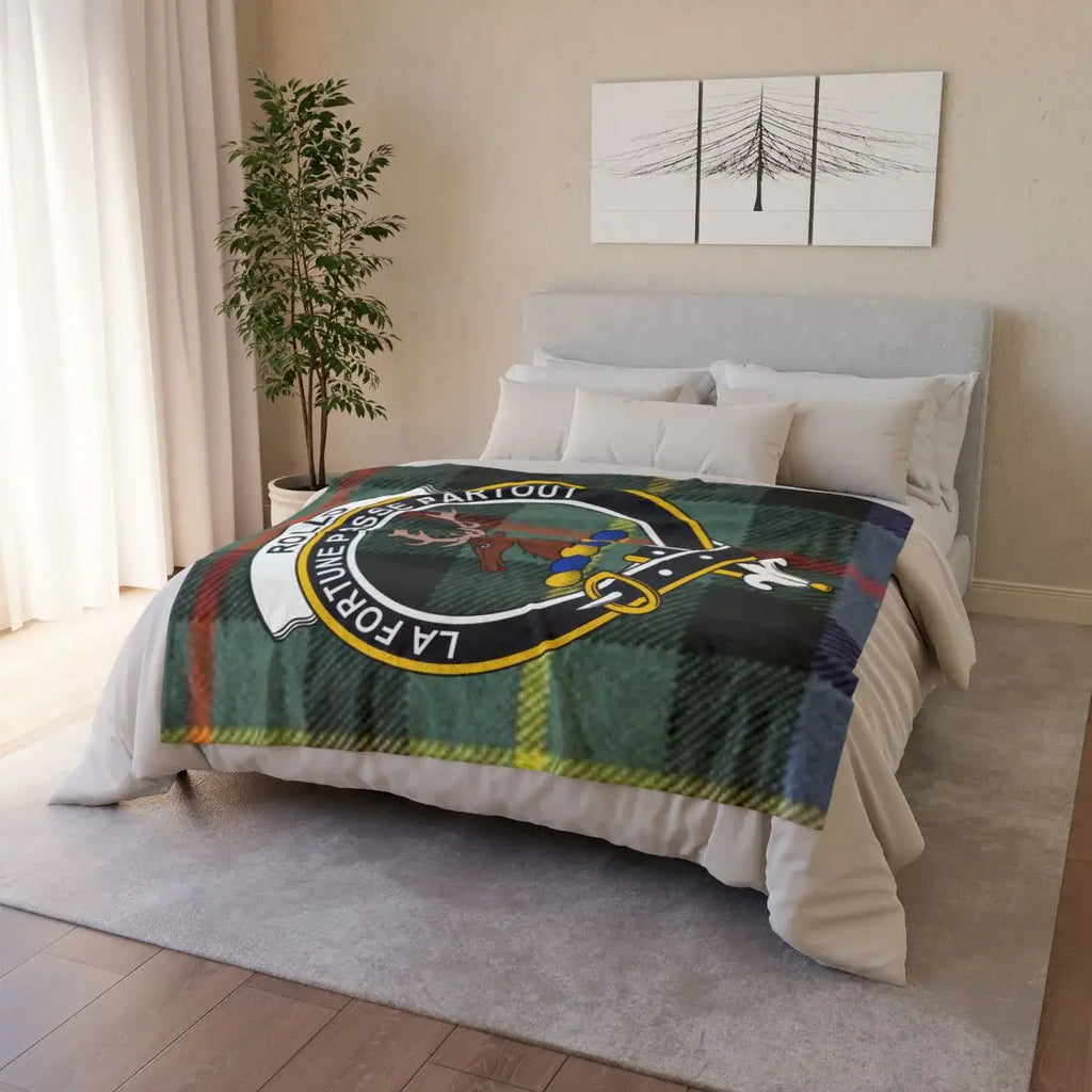 Rollo clan crest tartan throw draped on sofa — printed design, white reverse, hemmed edges