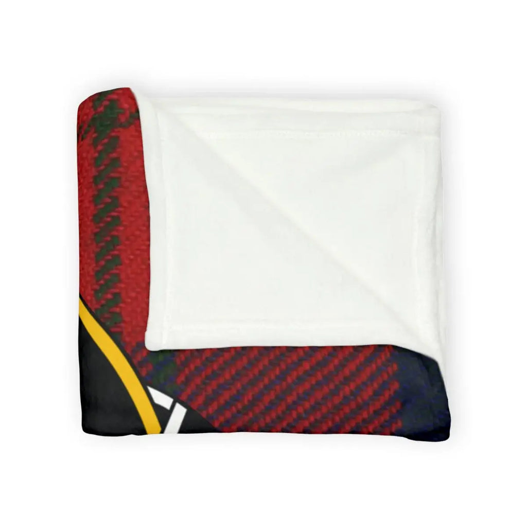 Ruthven tartan throw blanket on sofa — red and black plaid with clan crest