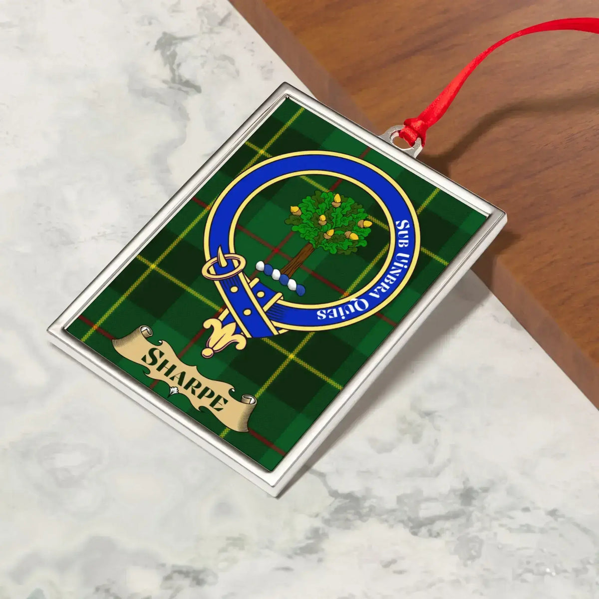 Sharpe ornament hanging from a Christmas tree branch by its satin ribbon