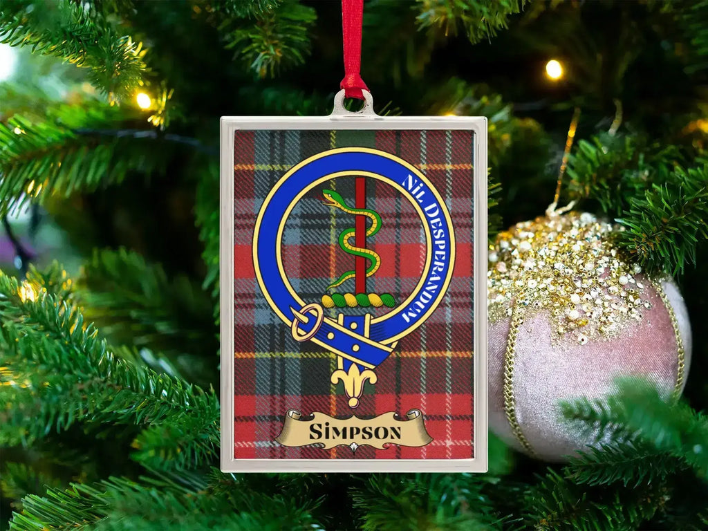 Simpson clan crest Christmas ornament in a silver frame on a tartan background