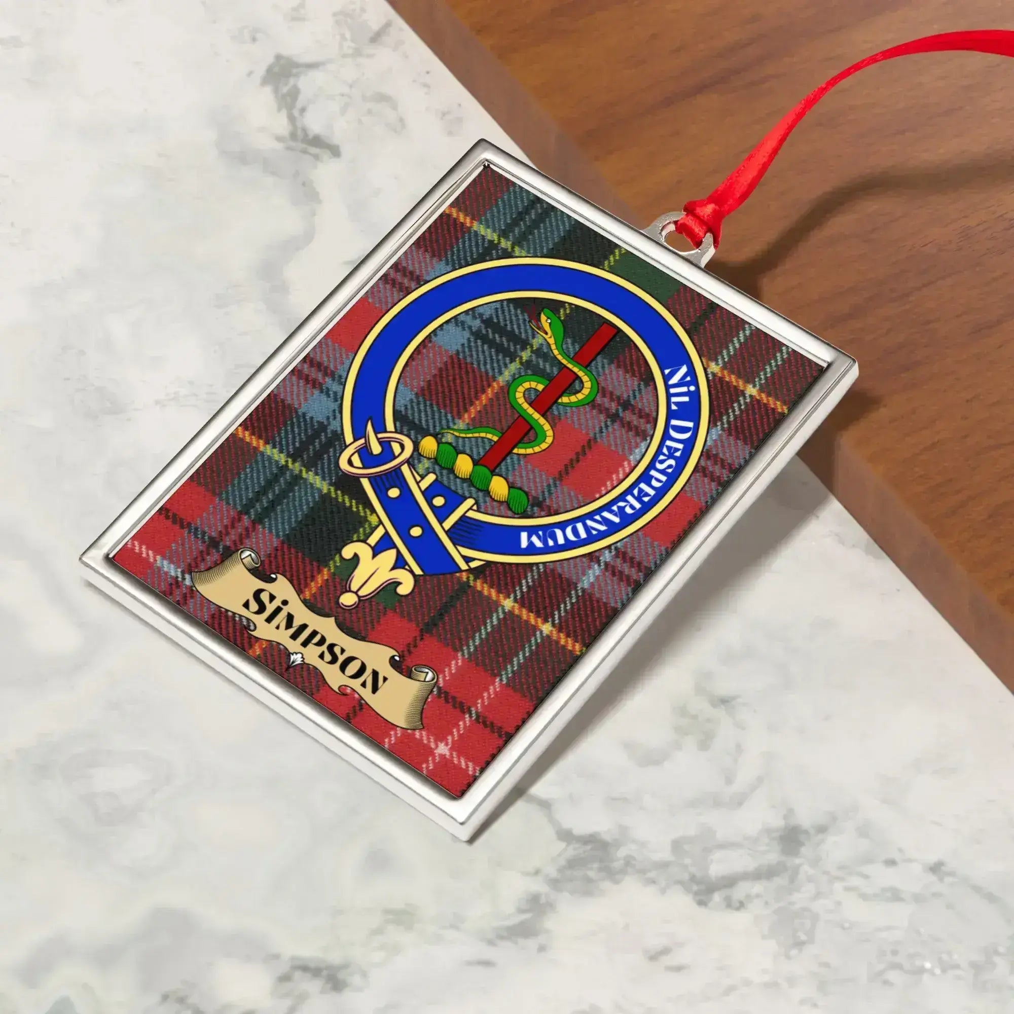 Simpson ornament hanging from a Christmas tree branch by its satin ribbon