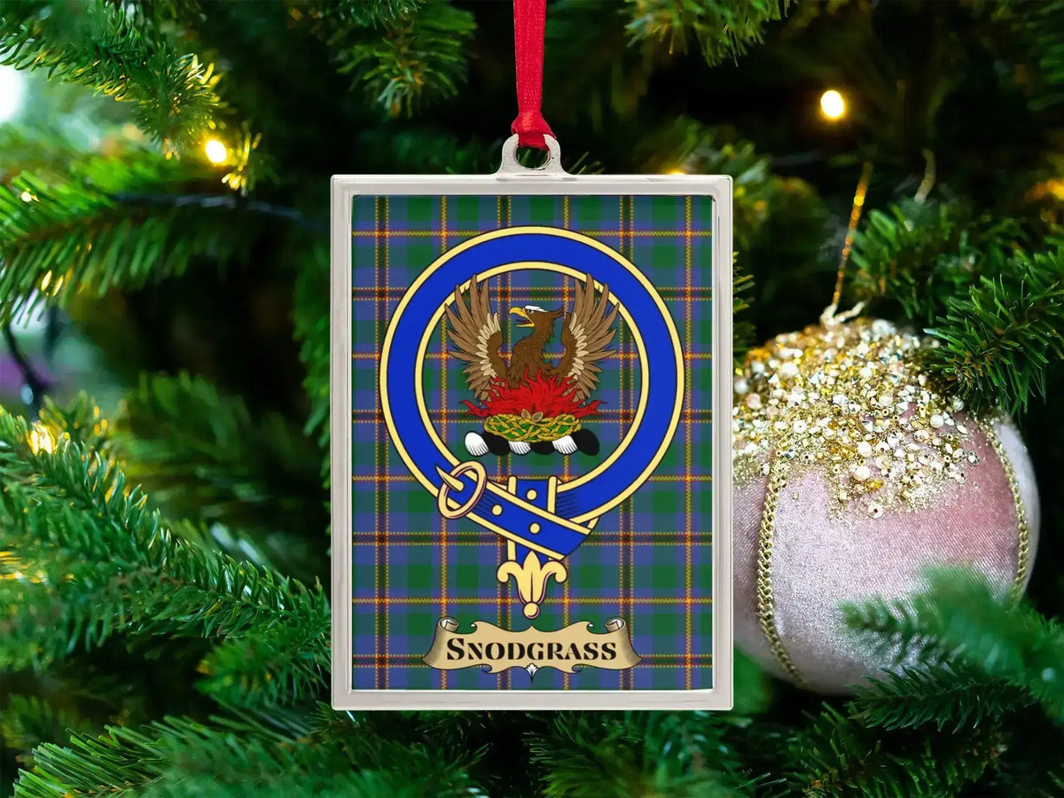 Snodgrass clan crest Christmas ornament in a silver frame on a tartan background