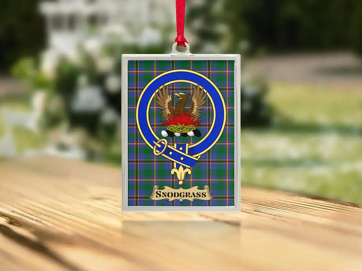 Close-up of the Snodgrass family crest on a polished silver-frame metal ornament