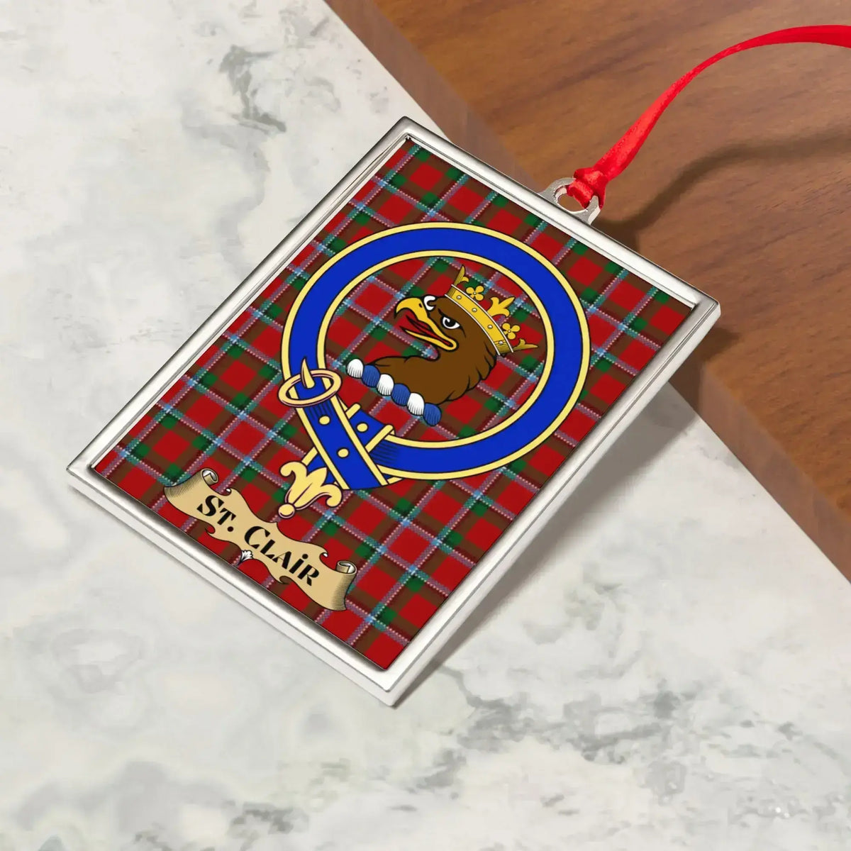 St Clair ornament hanging from a Christmas tree branch by its satin ribbon