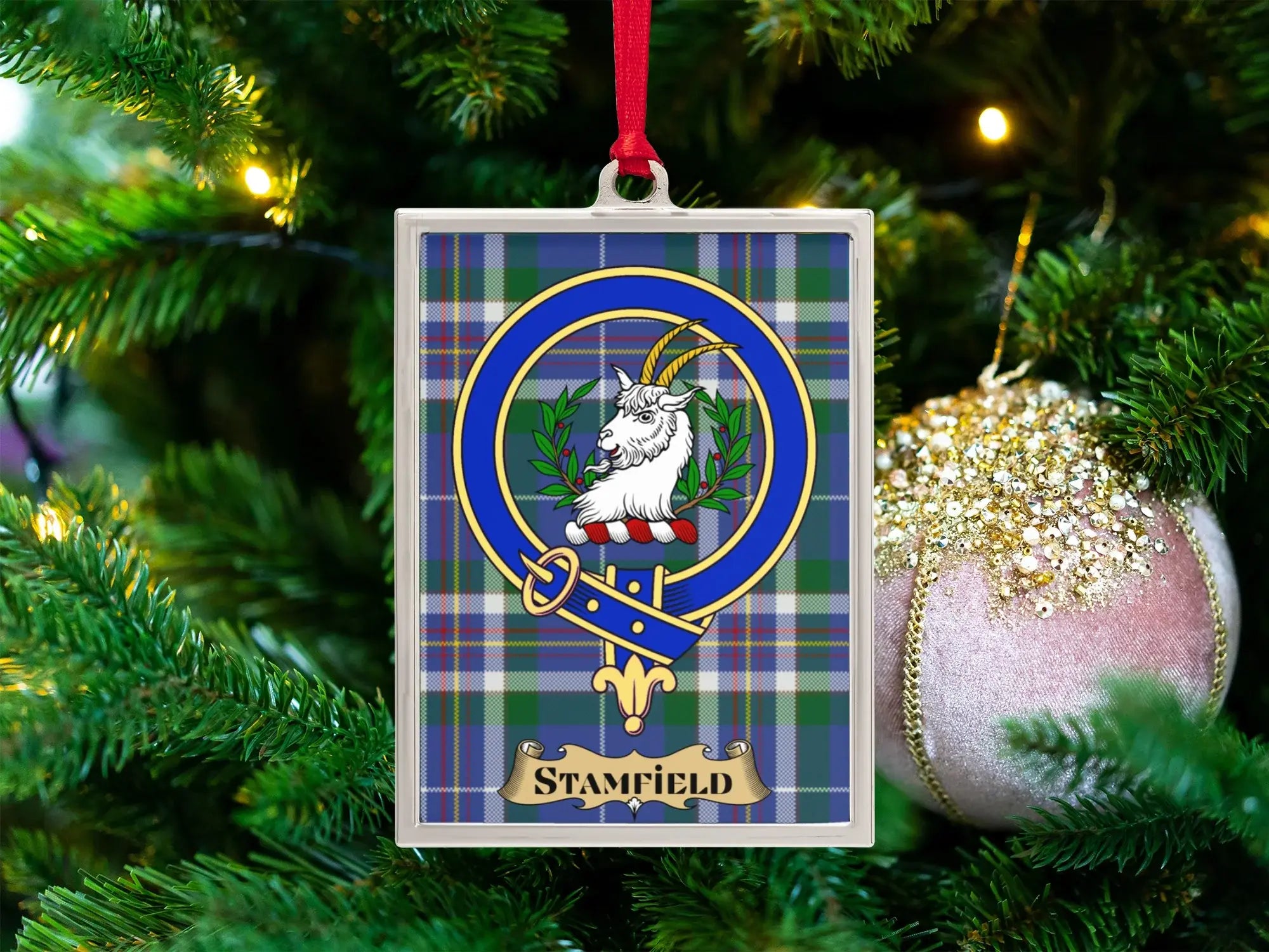 Stamfield clan crest Christmas ornament in a silver frame on a tartan background