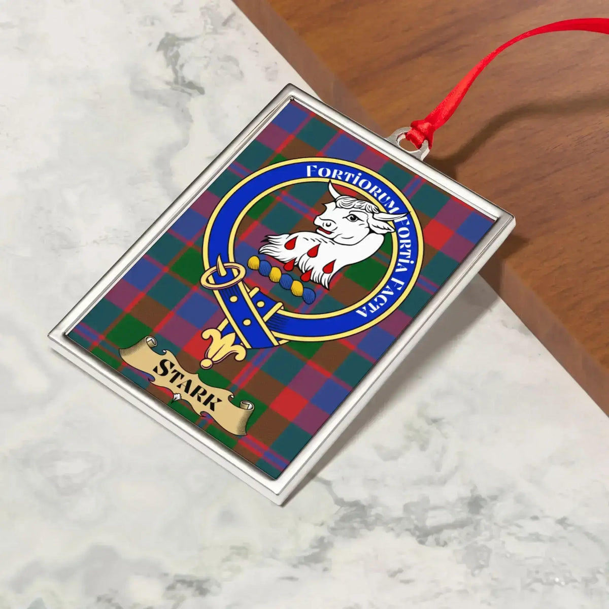 Stark ornament hanging from a Christmas tree branch by its satin ribbon