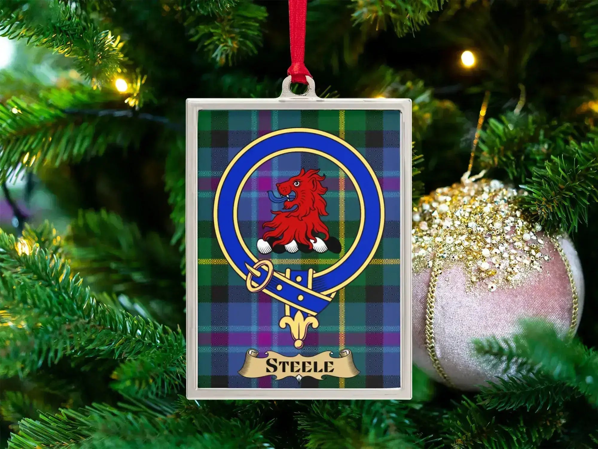 Steele clan crest Christmas ornament in a silver frame on a tartan background