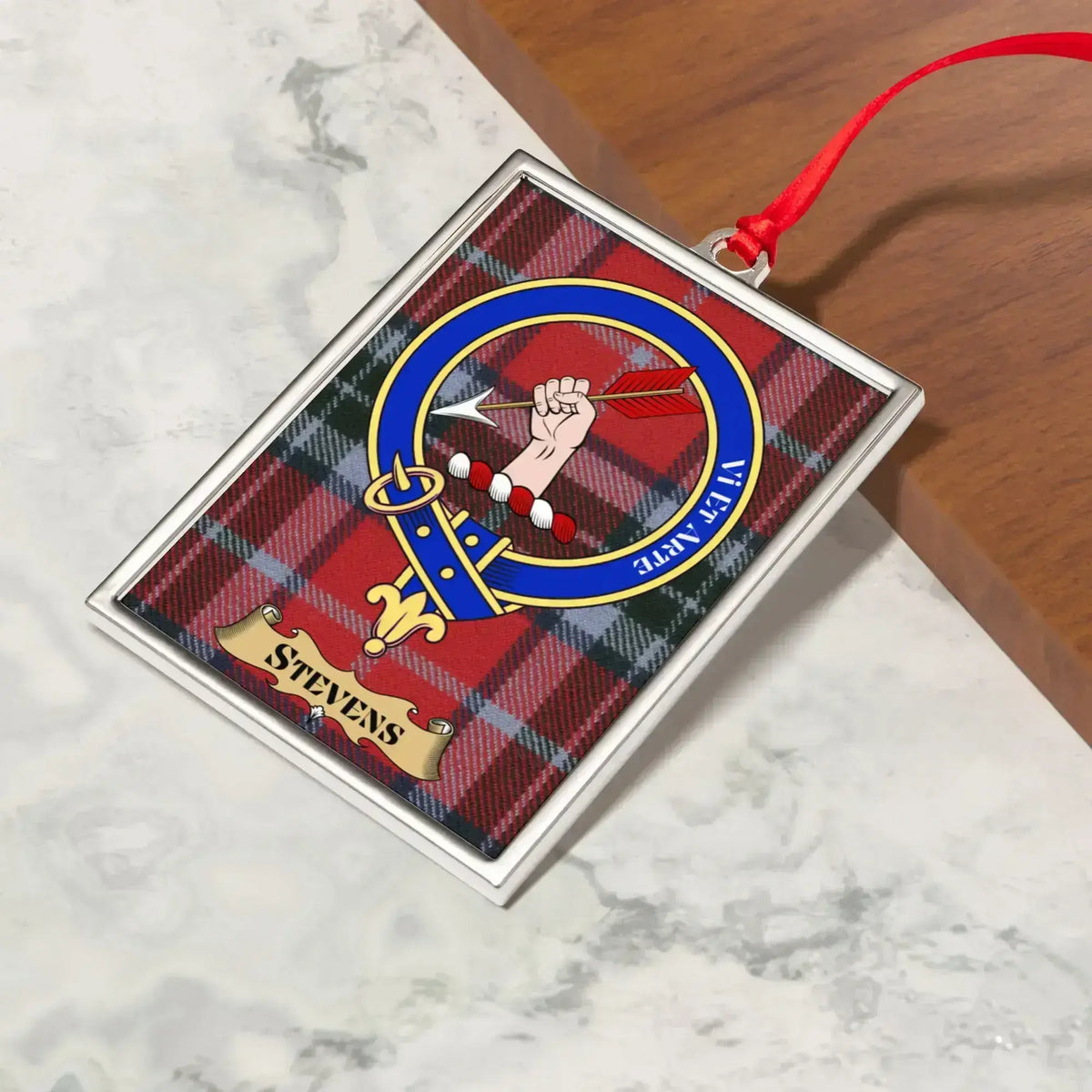 Stevens ornament hanging from a Christmas tree branch by its satin ribbon