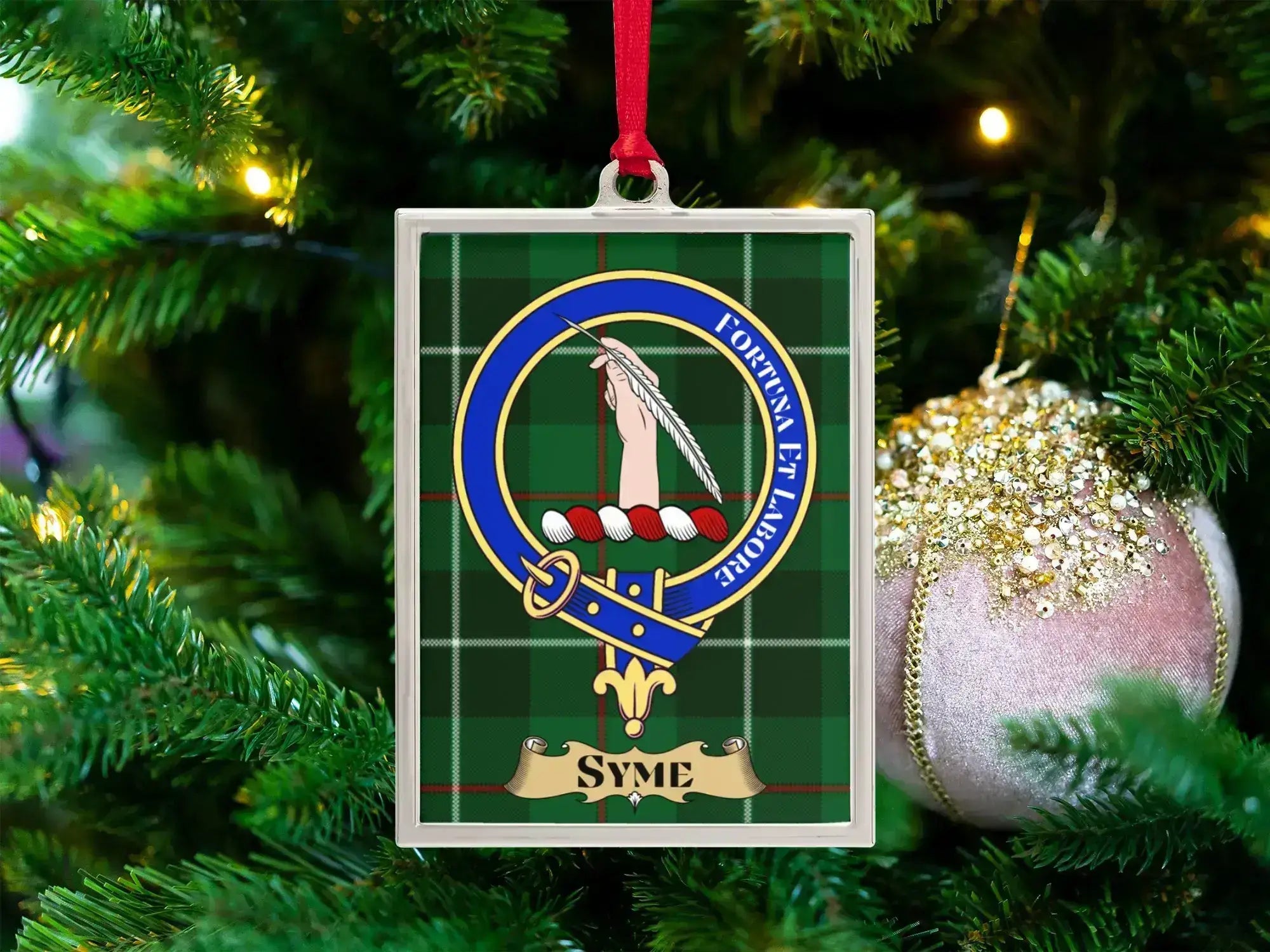 Syme clan crest Christmas ornament in a silver frame on a tartan background