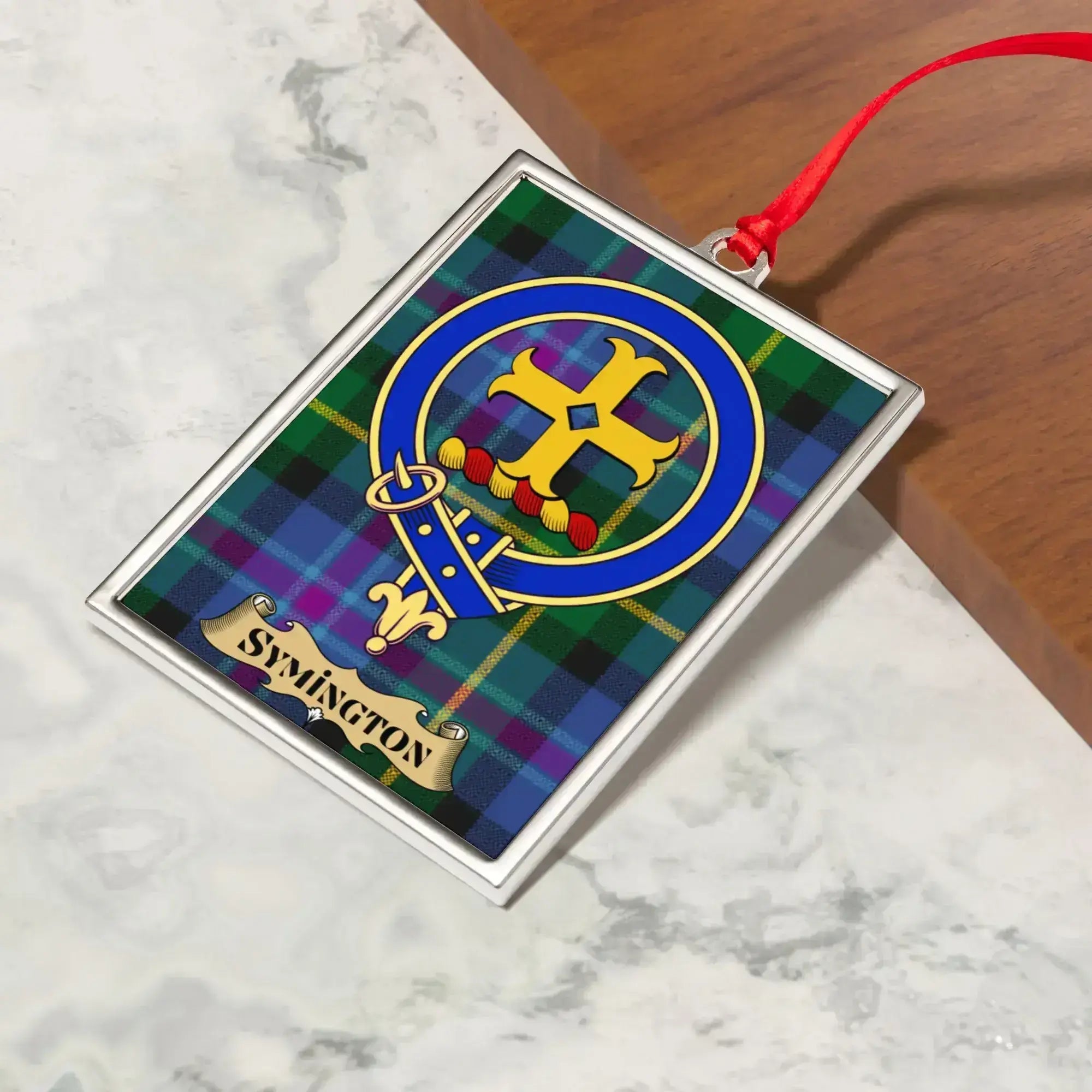 Symington ornament hanging from a Christmas tree branch by its satin ribbon