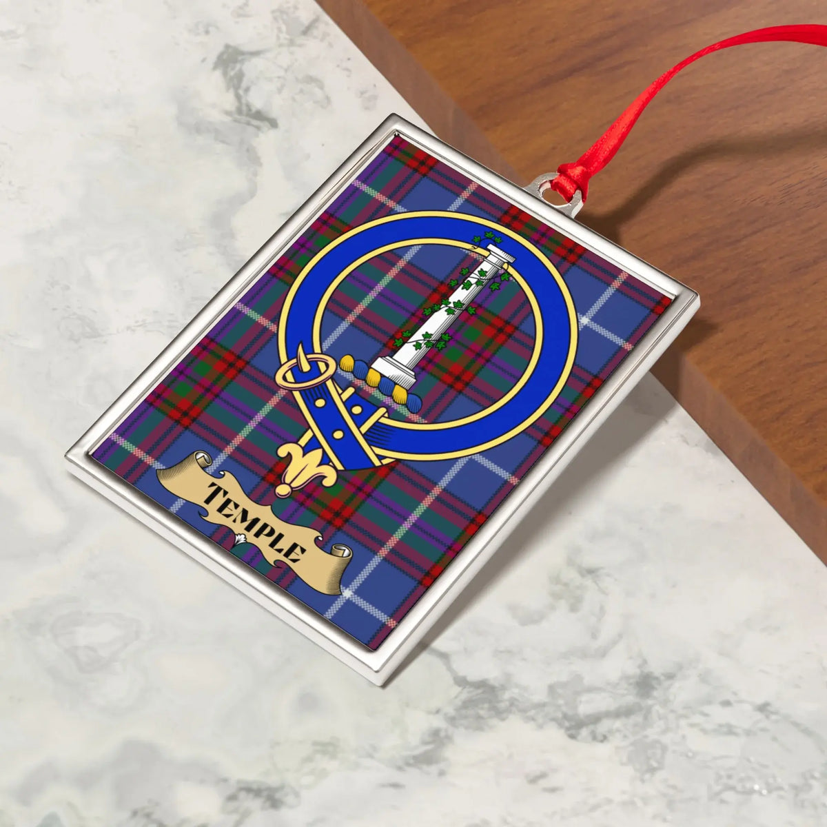 Temple ornament hanging from a Christmas tree branch by its satin ribbon