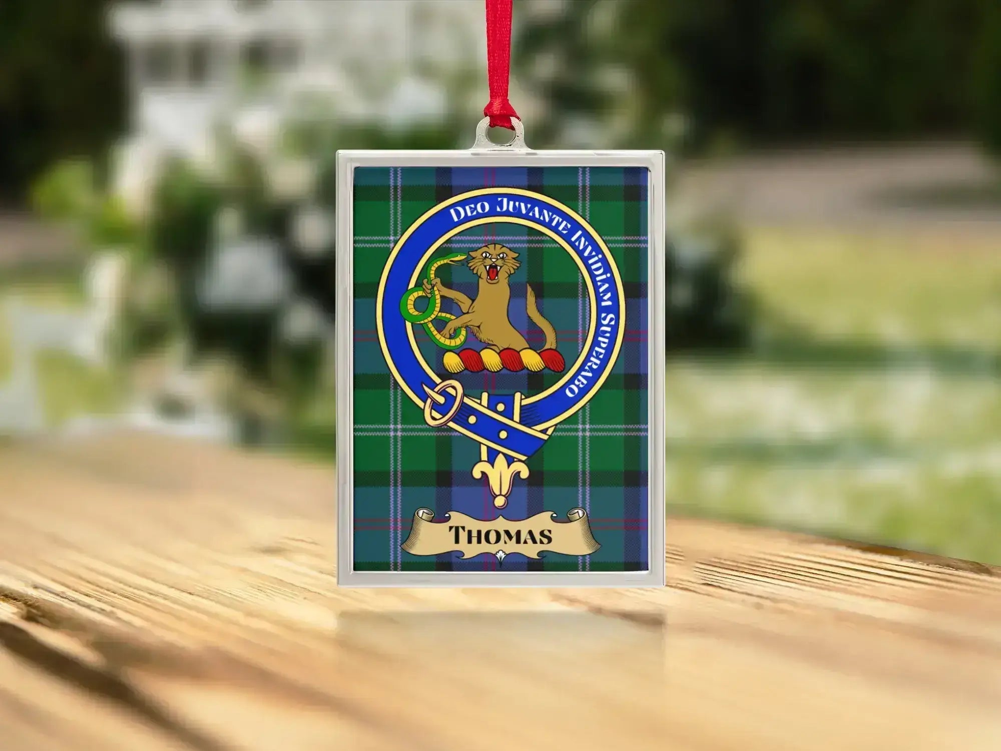 Close-up of the Thomas family crest on a polished silver-frame metal ornament