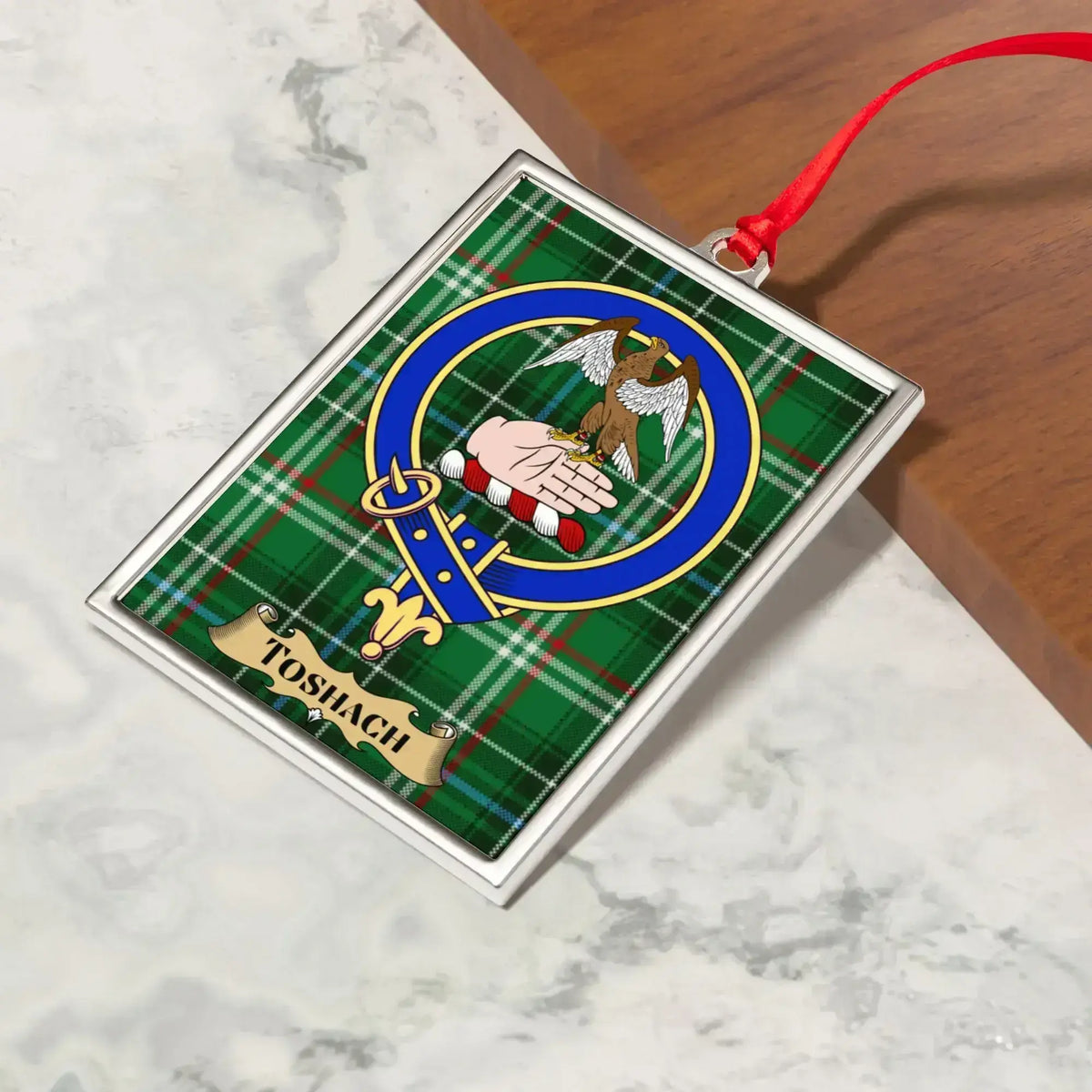 Toshach ornament hanging from a Christmas tree branch by its satin ribbon