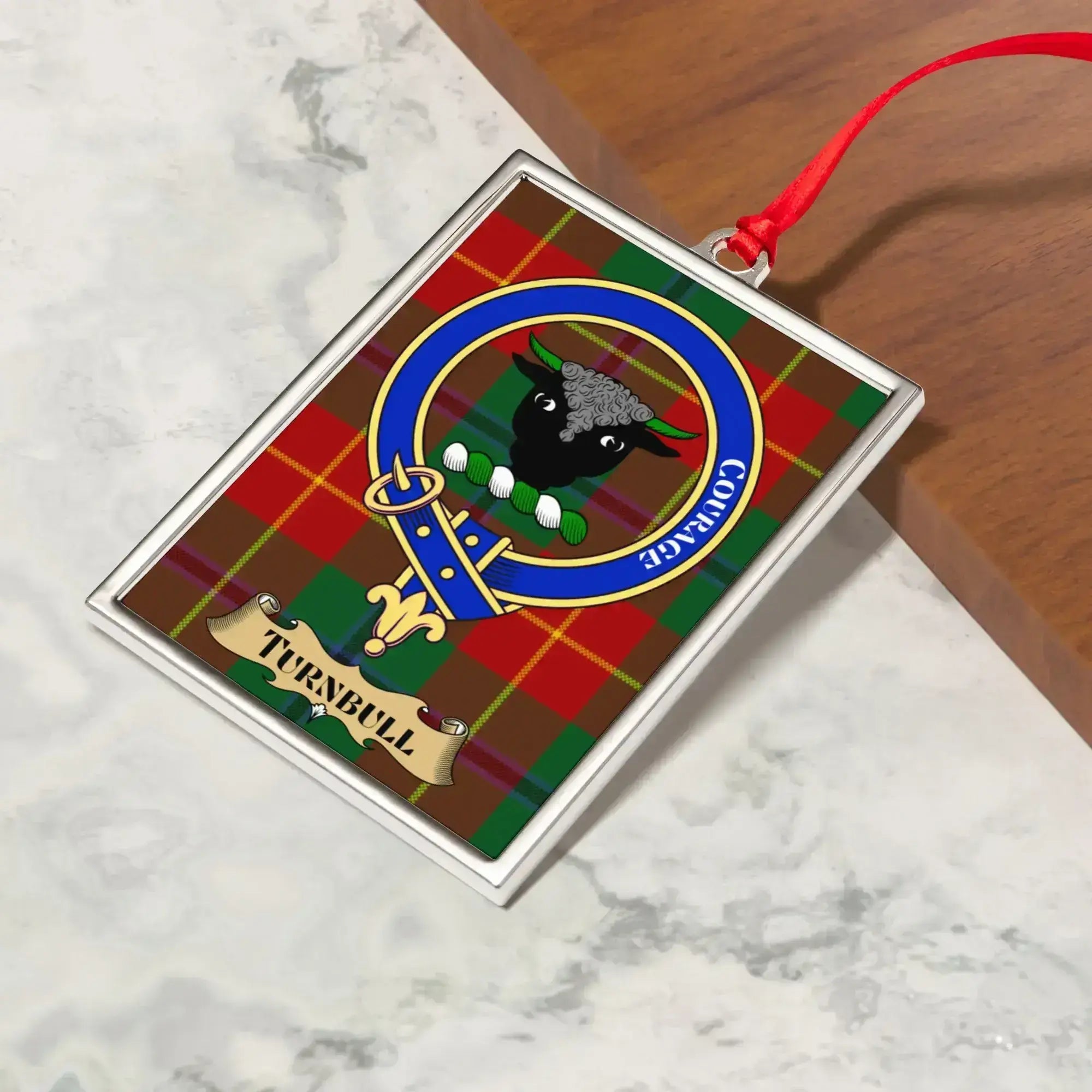 Turnbull ornament hanging from a Christmas tree branch by its satin ribbon