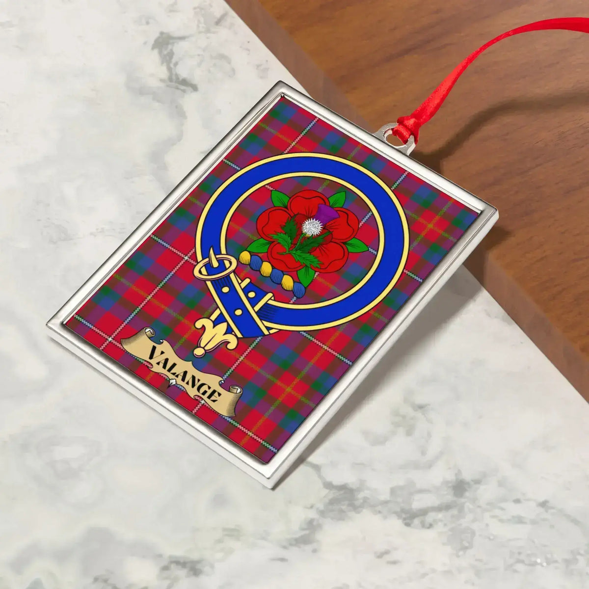 Valange ornament hanging from a Christmas tree branch by its satin ribbon