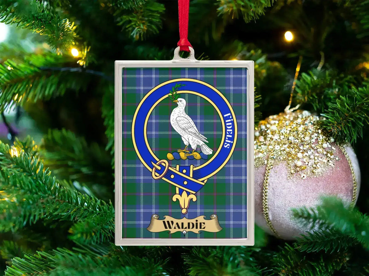 Waldie clan crest Christmas ornament in a silver frame on a tartan background