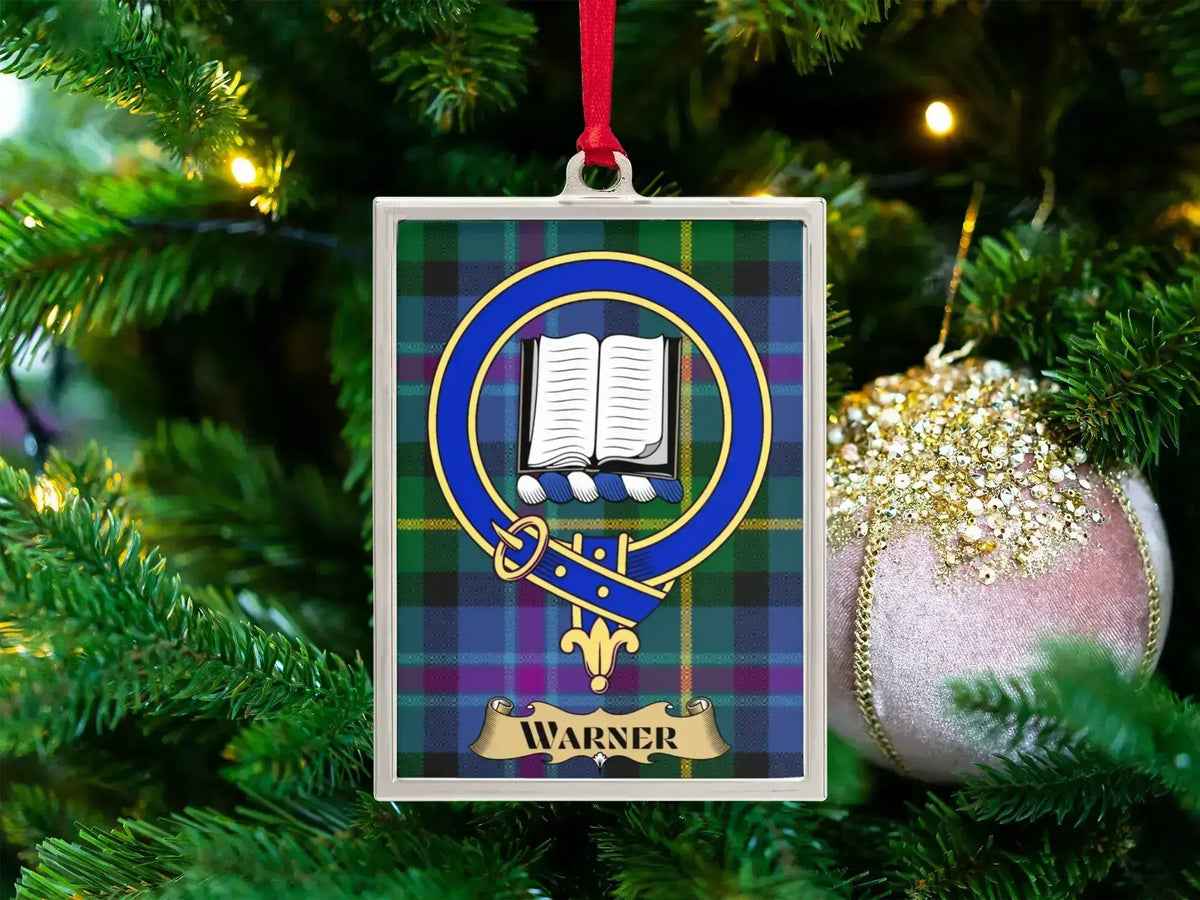 Warner clan crest Christmas ornament in a silver frame on a tartan background
