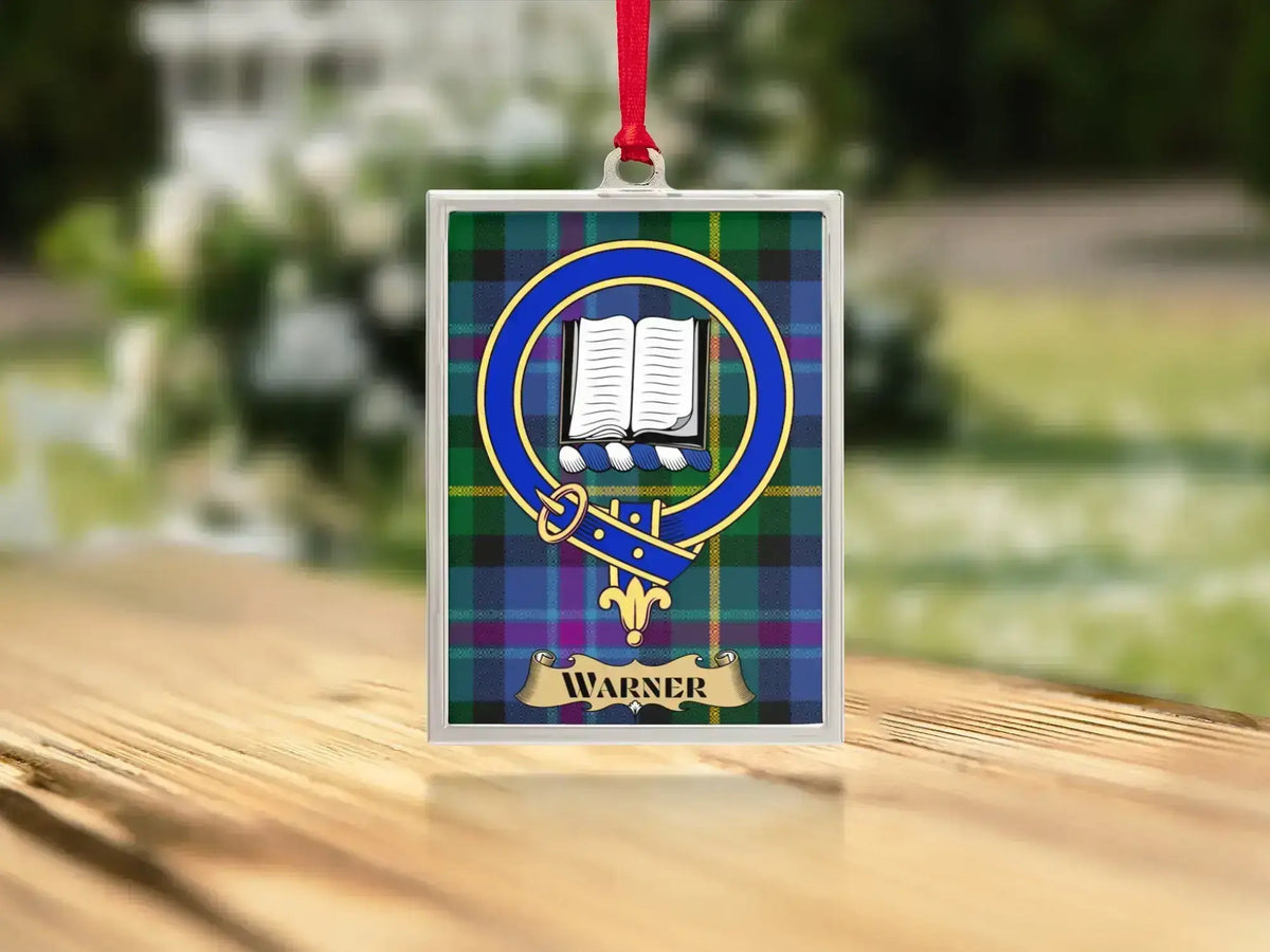 Close-up of the Warner family crest on a polished silver-frame metal ornament