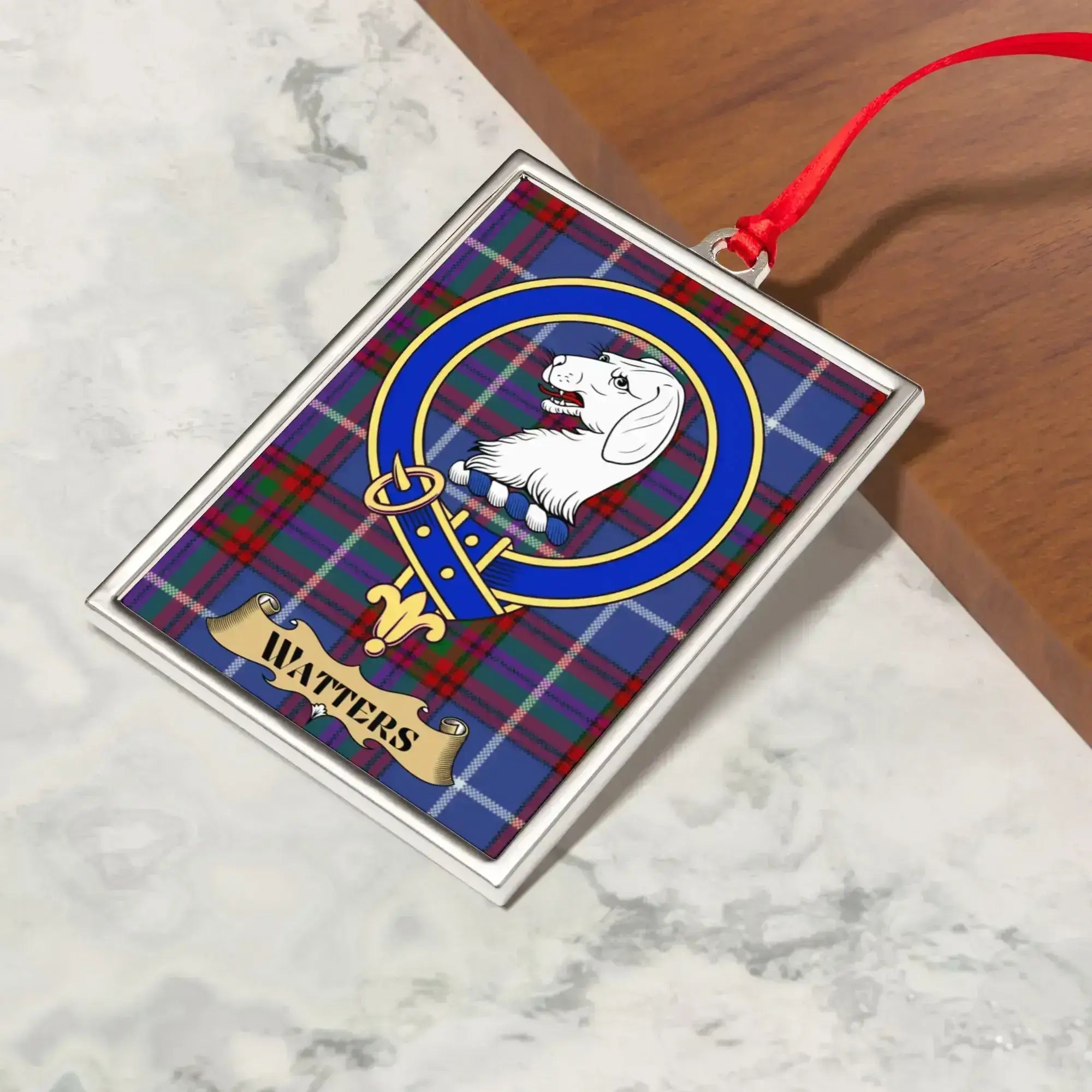 Watters ornament hanging from a Christmas tree branch by its satin ribbon