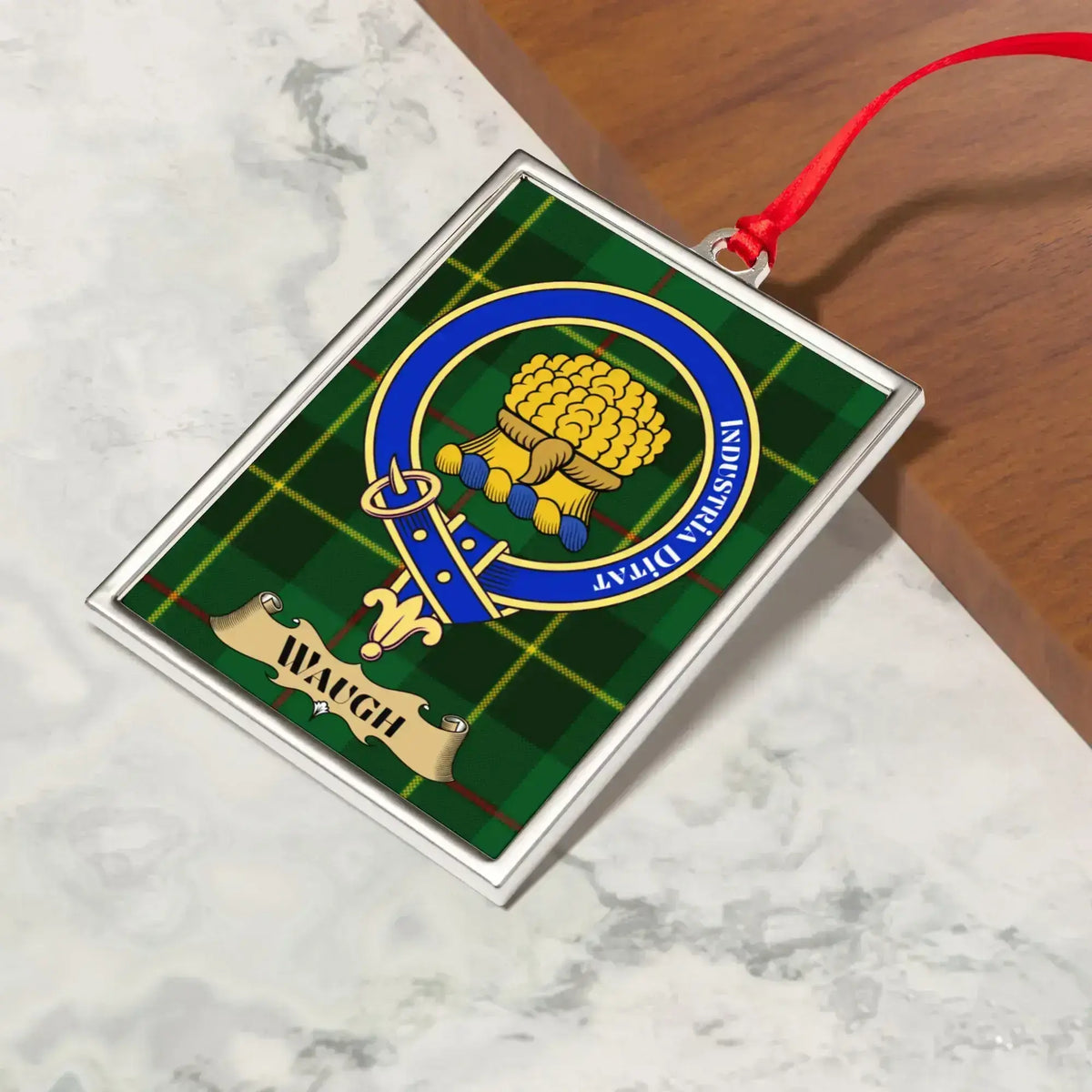 Waugh ornament hanging from a Christmas tree branch by its satin ribbon