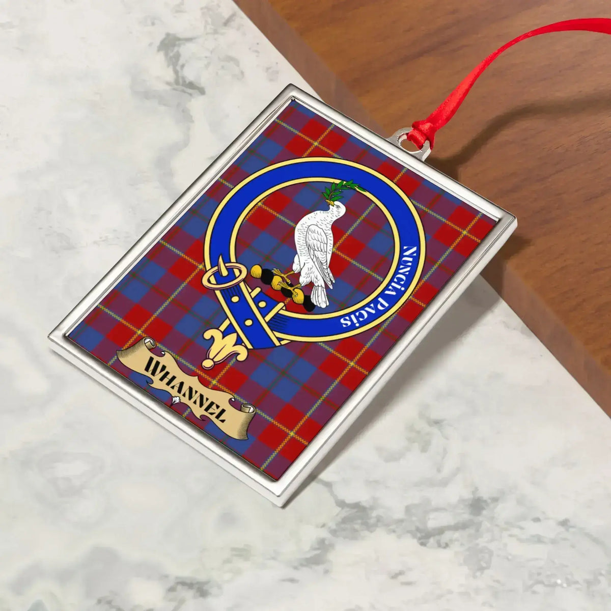 Whannel ornament hanging from a Christmas tree branch by its satin ribbon