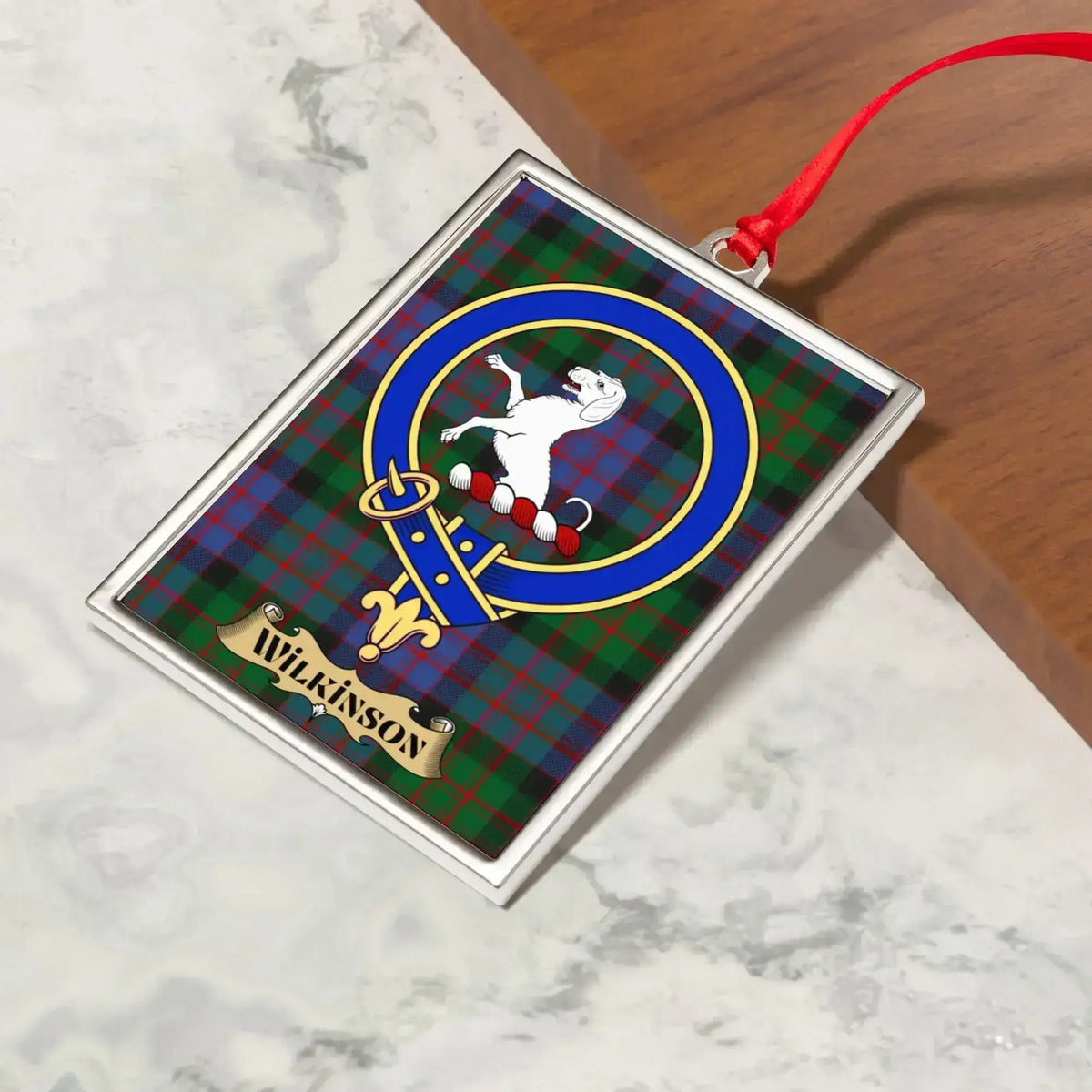 Wilkinson ornament hanging from a Christmas tree branch by its satin ribbon
