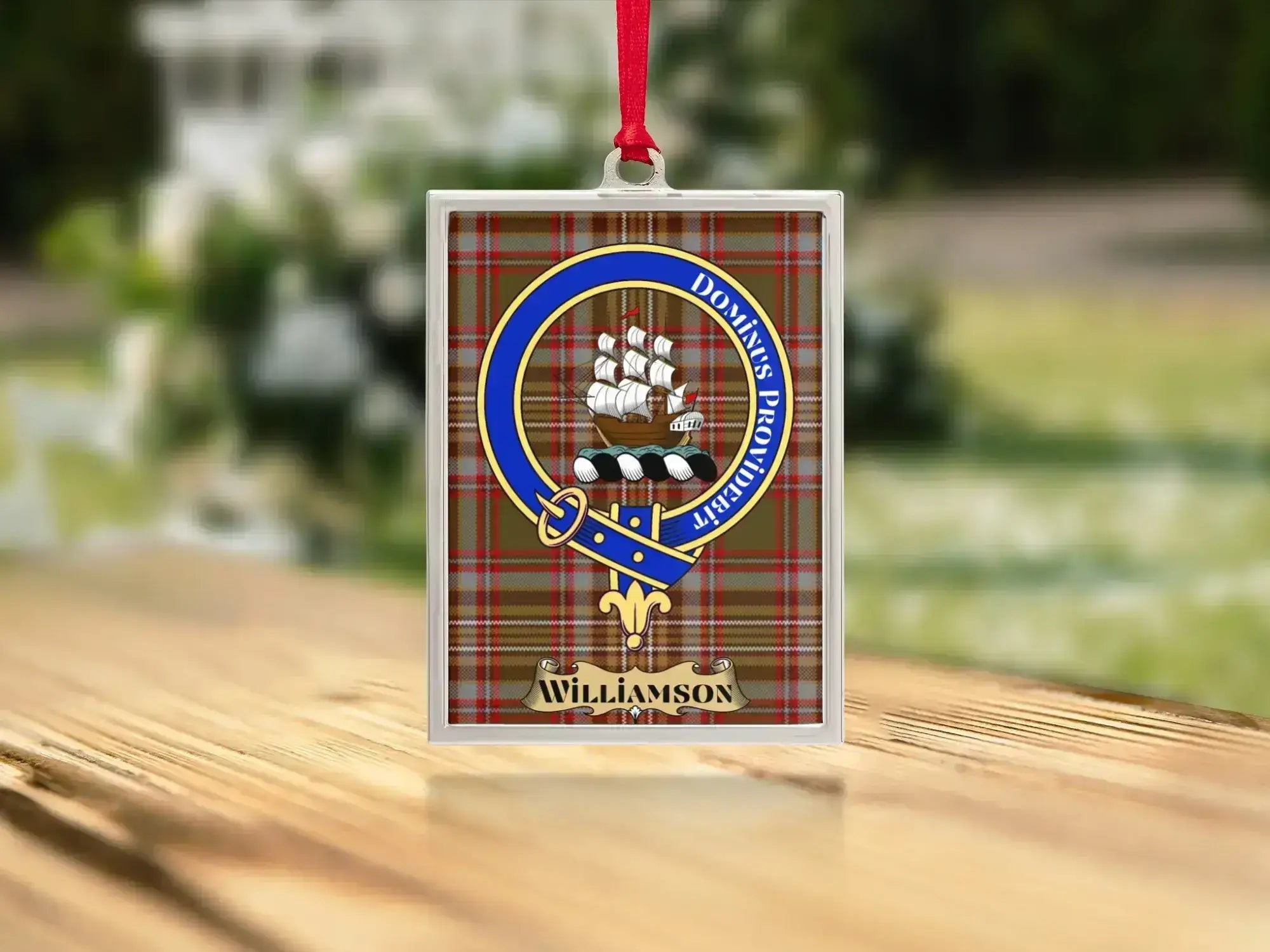 Close-up of the Williamson family crest on a polished silver-frame metal ornament
