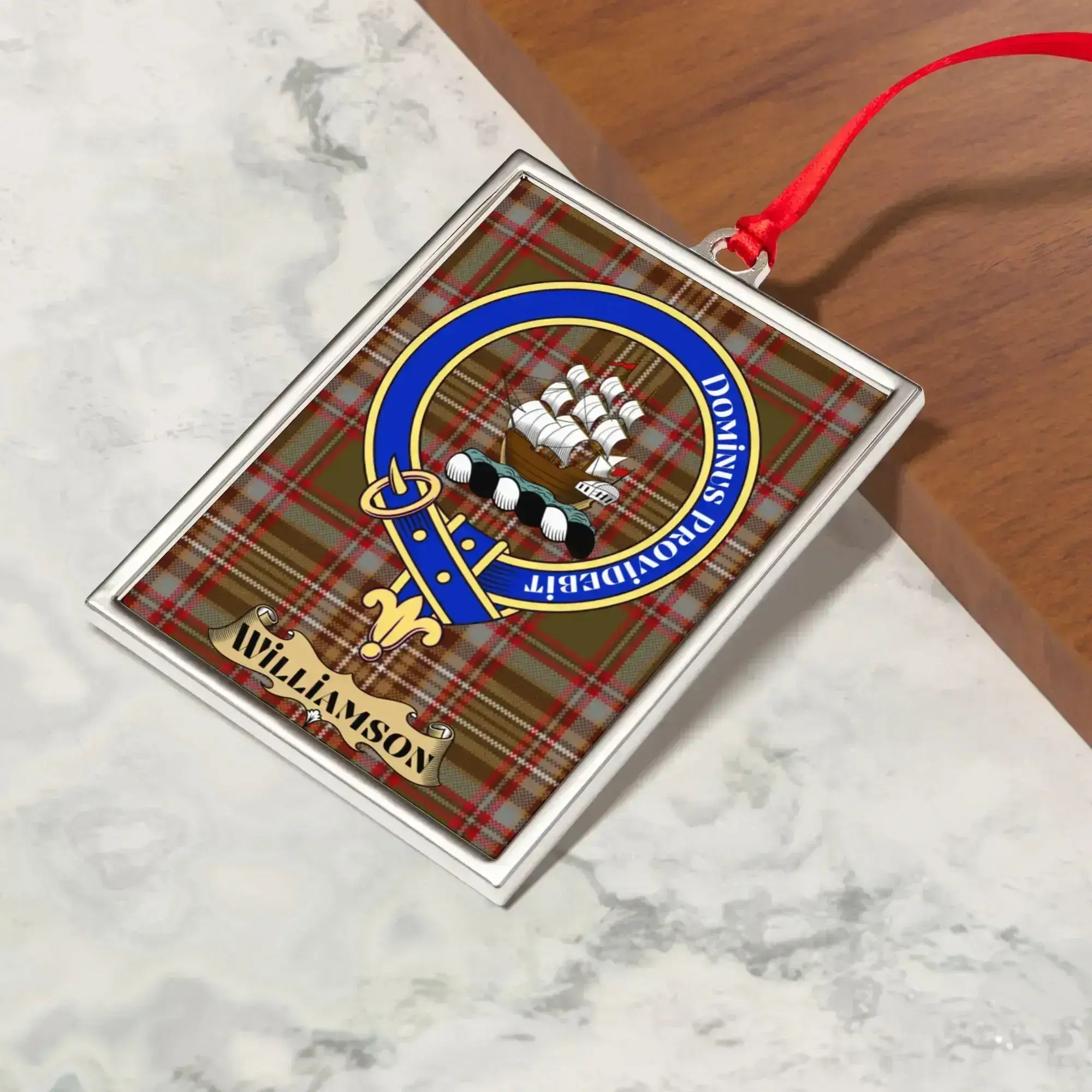 Williamson ornament hanging from a Christmas tree branch by its satin ribbon