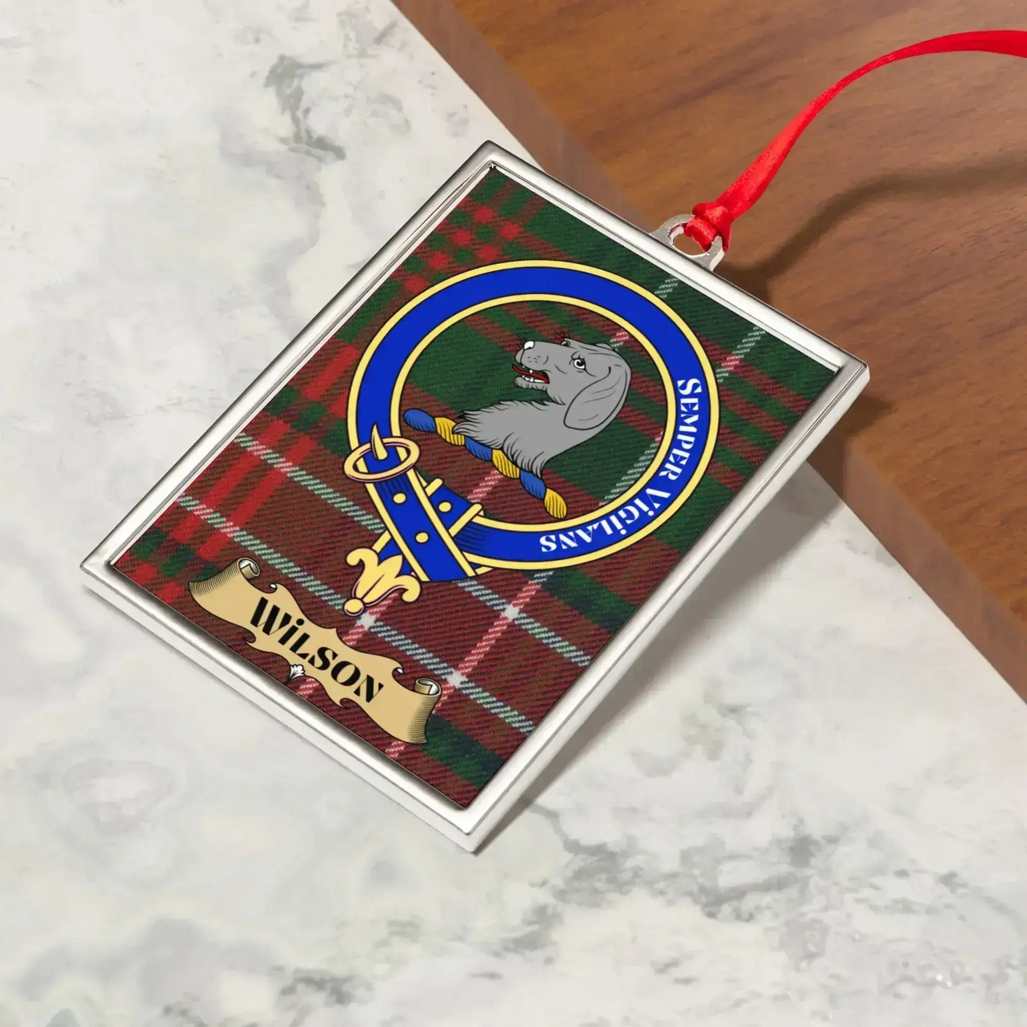 Wilson ornament hanging from a Christmas tree branch by its satin ribbon