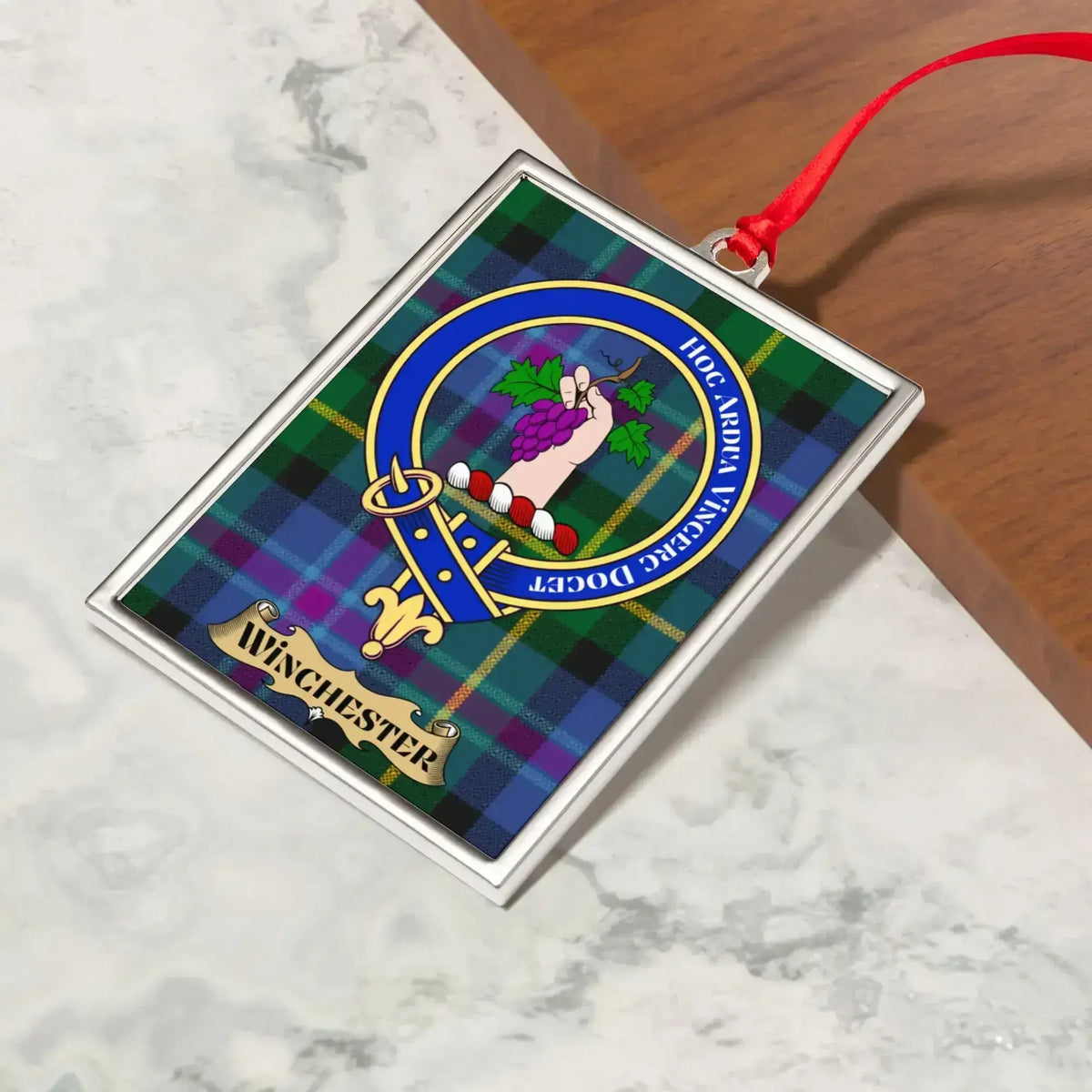 Winchester ornament hanging from a Christmas tree branch by its satin ribbon