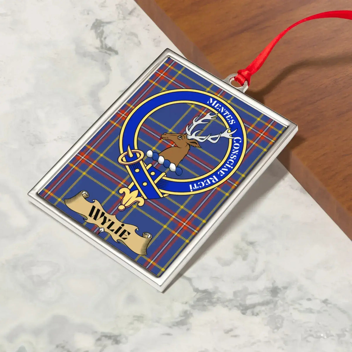 Wylie ornament hanging from a Christmas tree branch by its satin ribbon