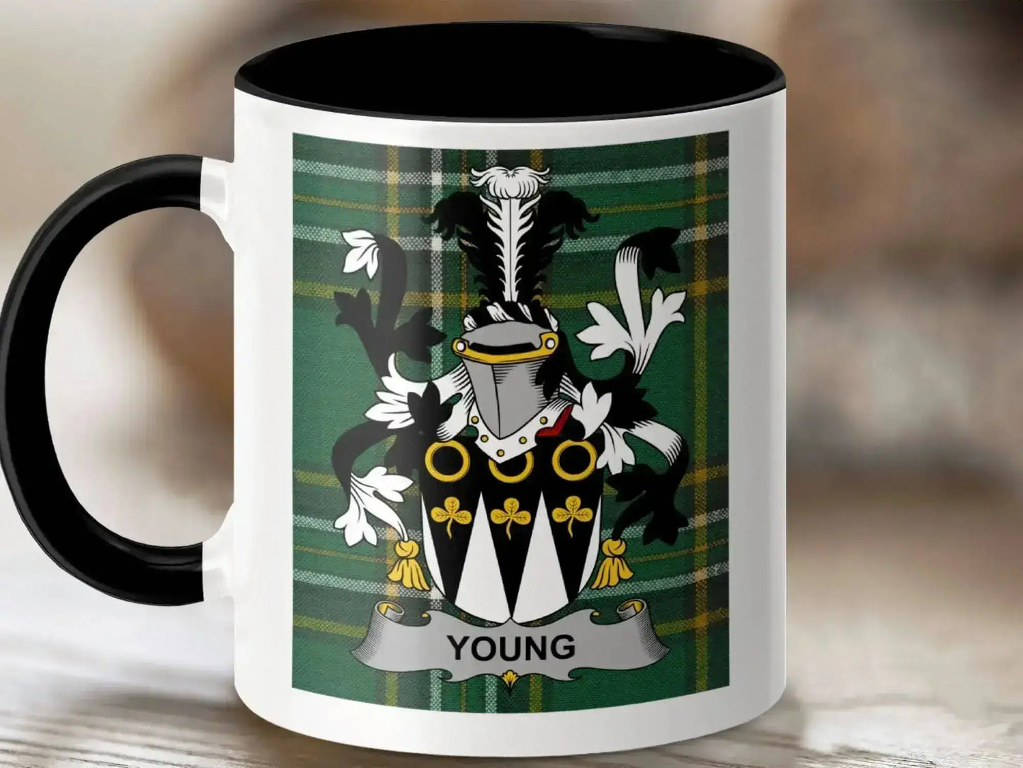White mug with black interior and handle featuring Young family crest on green tartan background