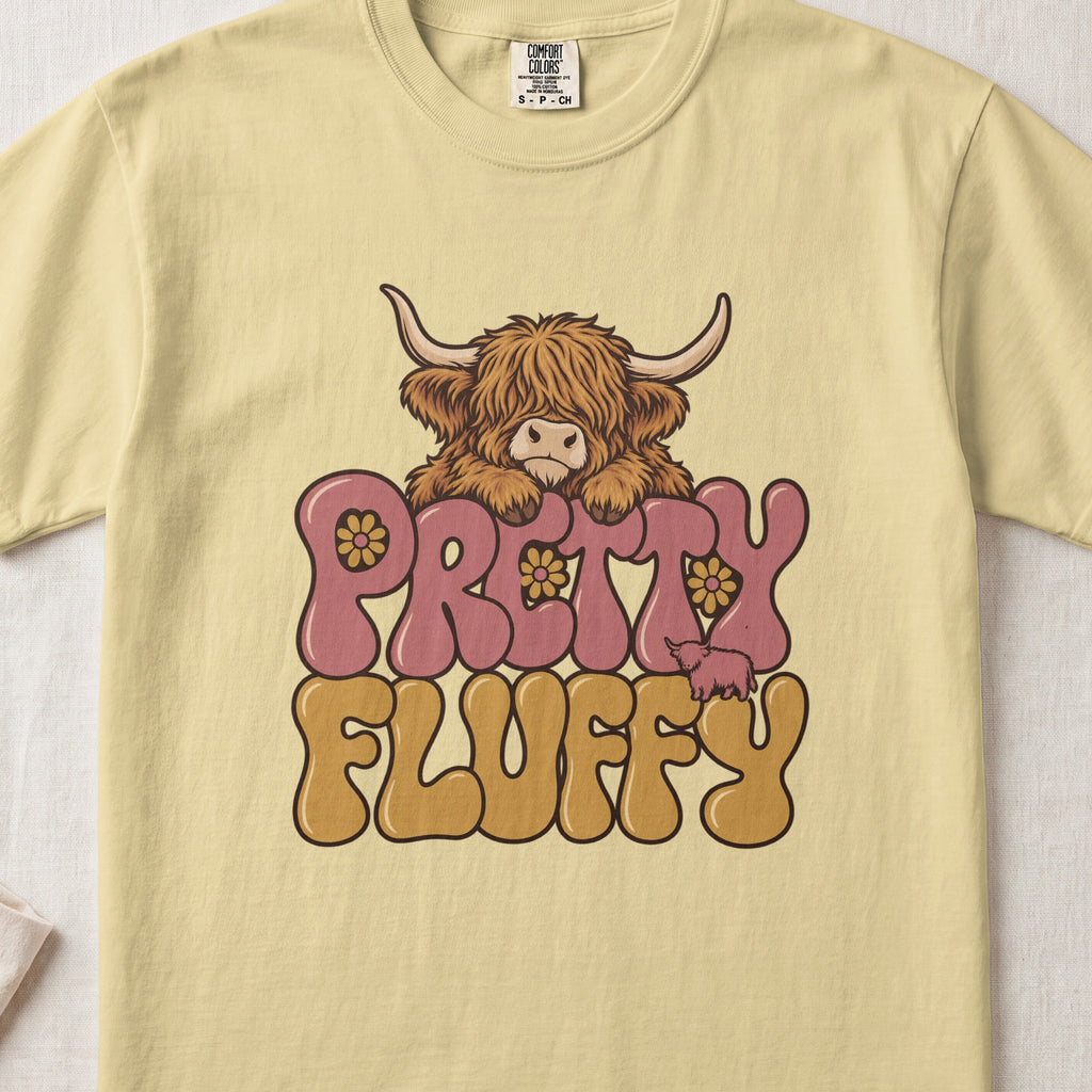 Pretty Fluffy Highland cow design on a Butter Comfort Colors 1717 T-shirt, flat lay