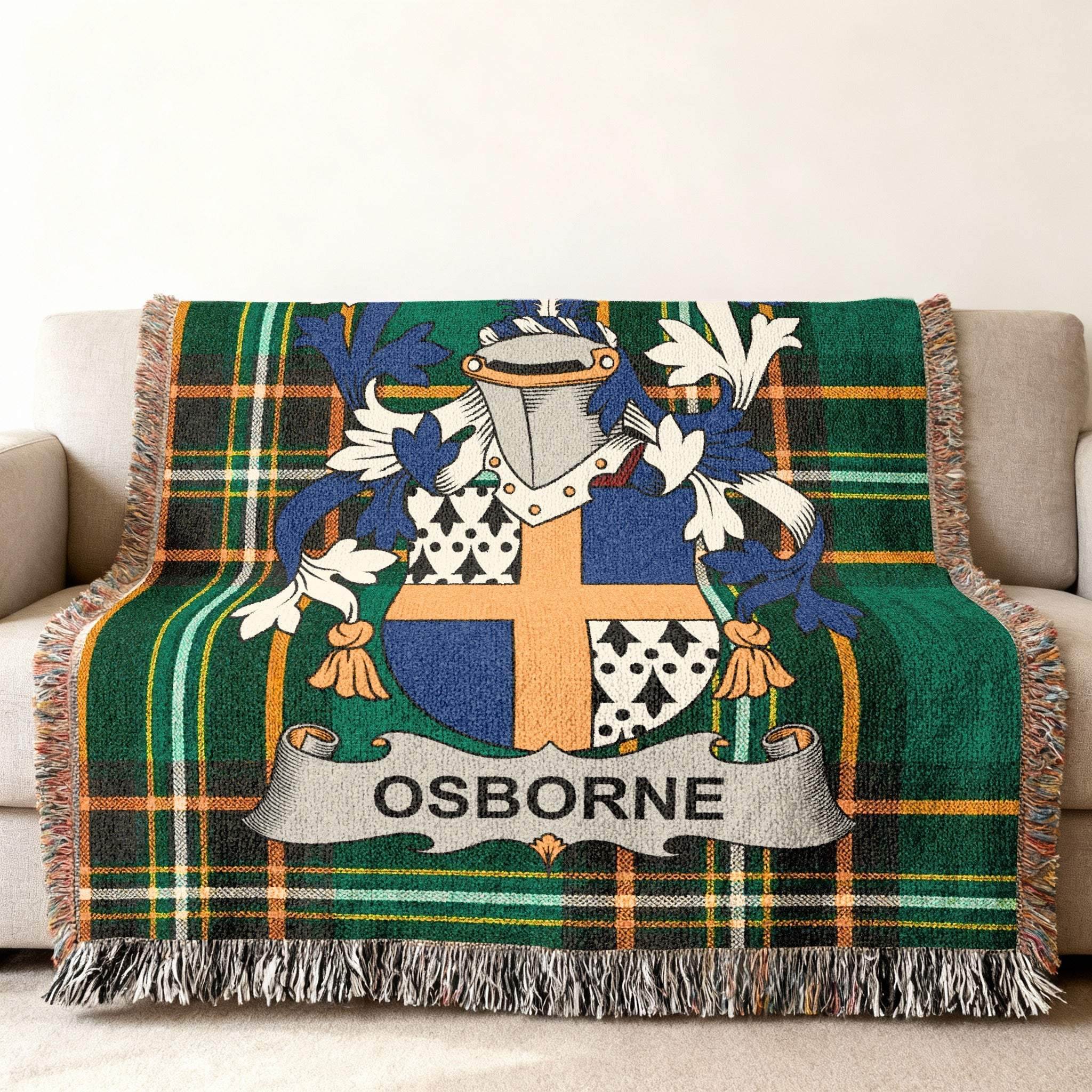 Tartan blanket with Osborne family crest on a sofa.