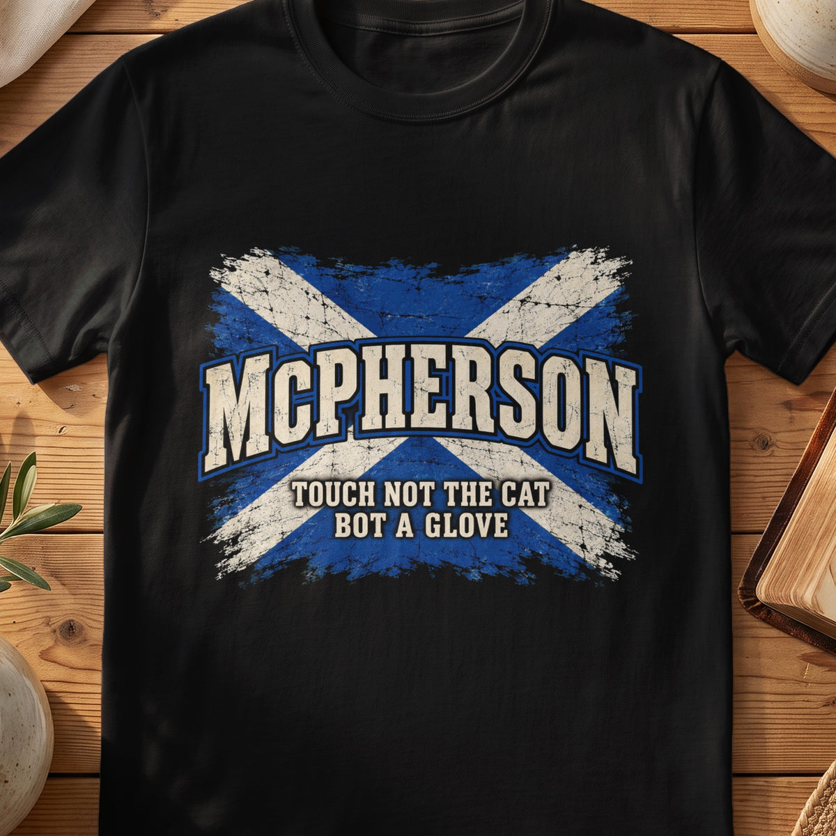 McPherson Scottish Saltire T-shirt in Black, with distressed blue and cream flag and “Touch Not the Cat Bot a Glove” lettering.