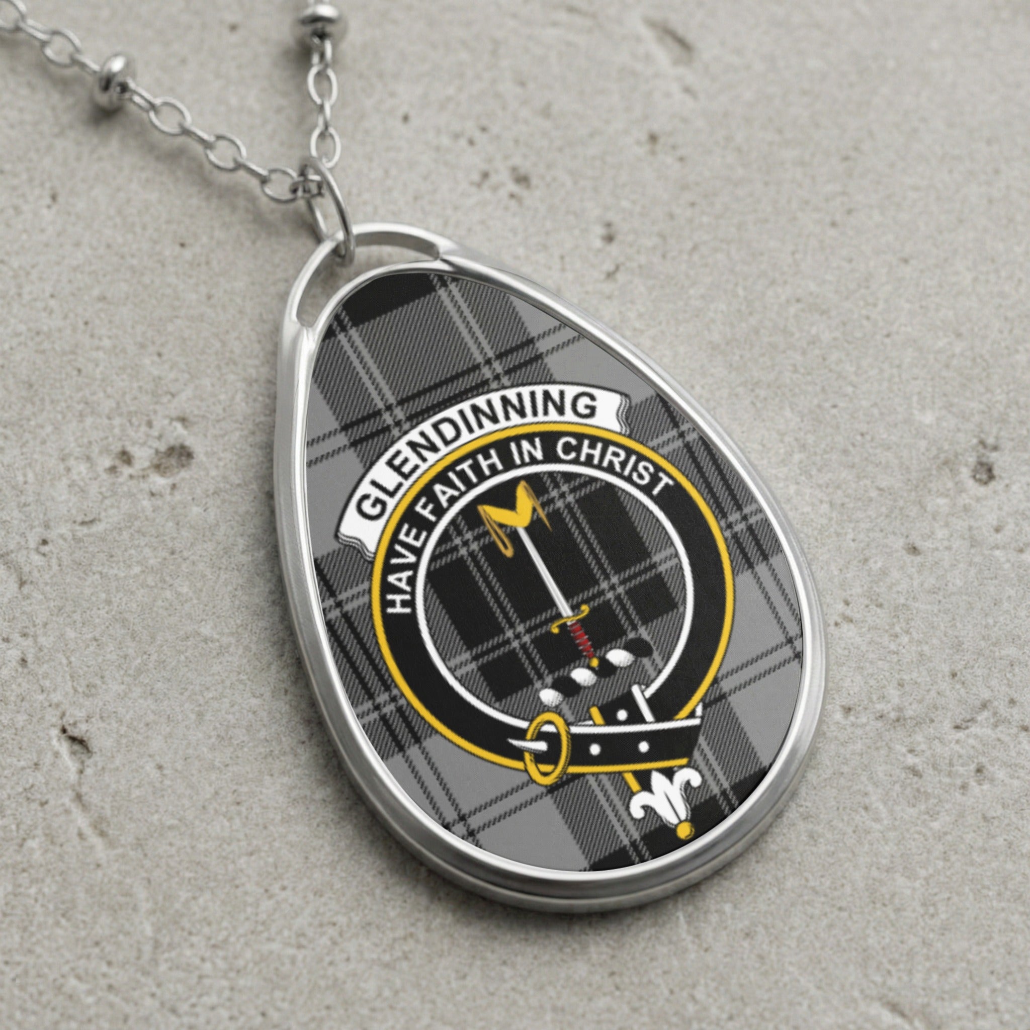 Glendinning clan Scottish tartan necklace with clan crest and Have Faith in Christ motto on tartan background