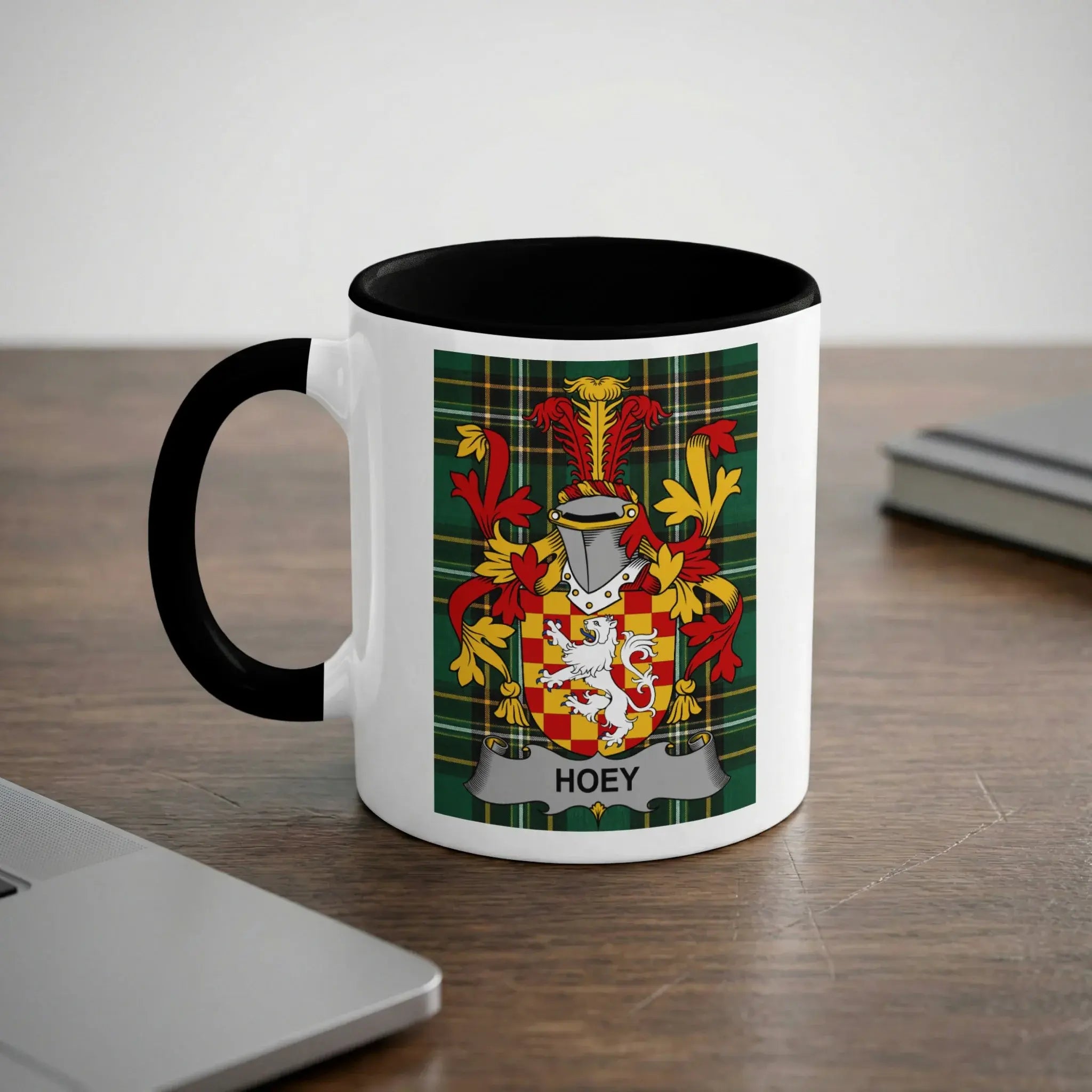 Mug with black rim and handle featuring the Hoey family crest on a green plaid background.