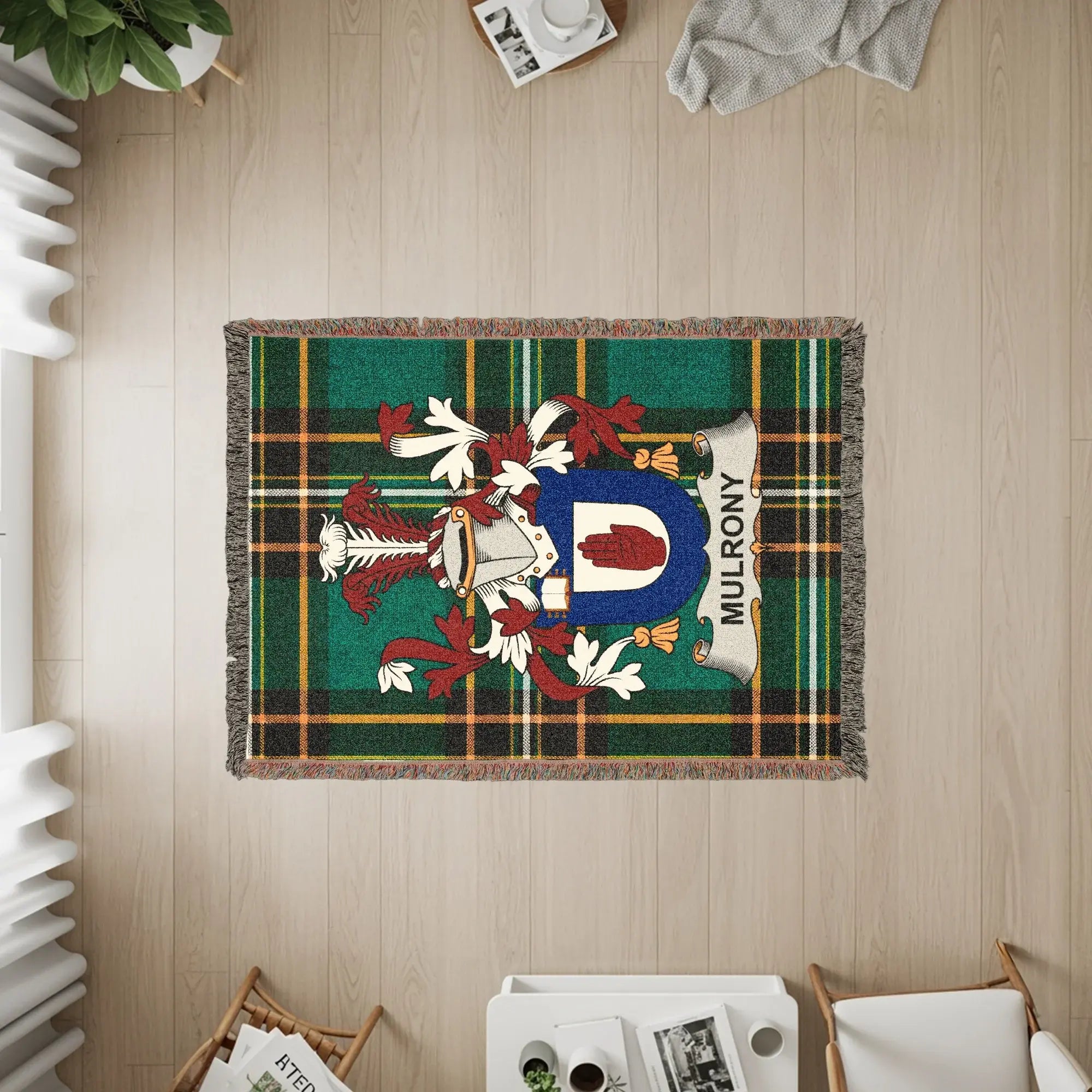 Woven blanket with a green tartan and the Mulroney coat of arms.