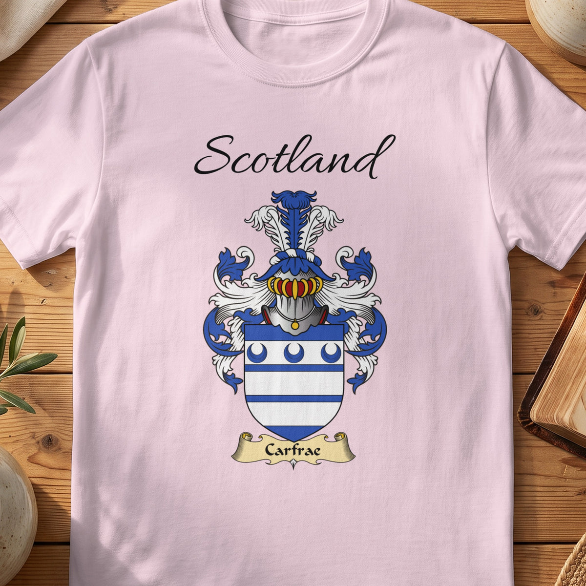 Light Pink Carfrae Scottish family shield T-shirt featuring blue horizontal stripes beneath blue crescents