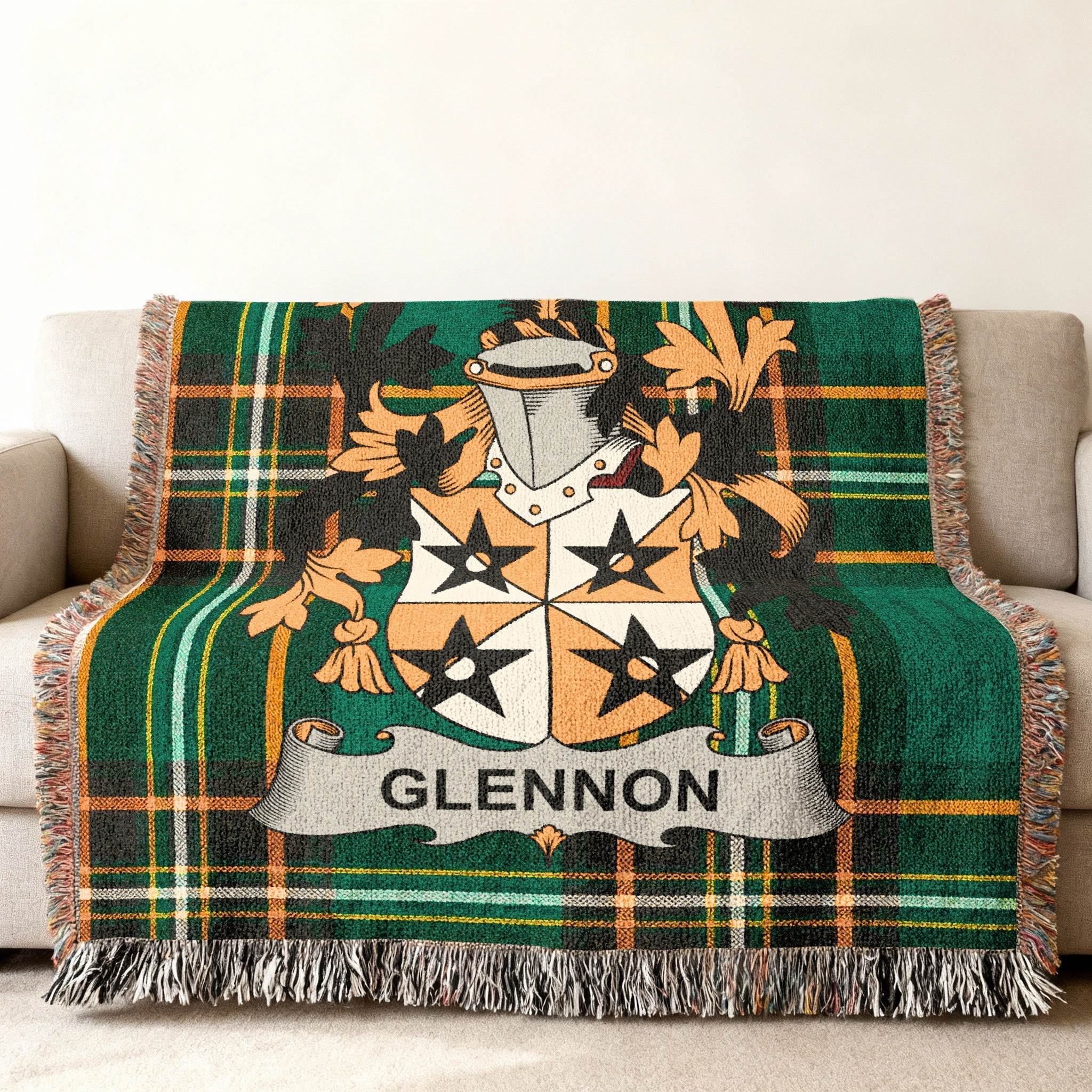 Green tartan blanket with Glennon family crest draped on a sofa.