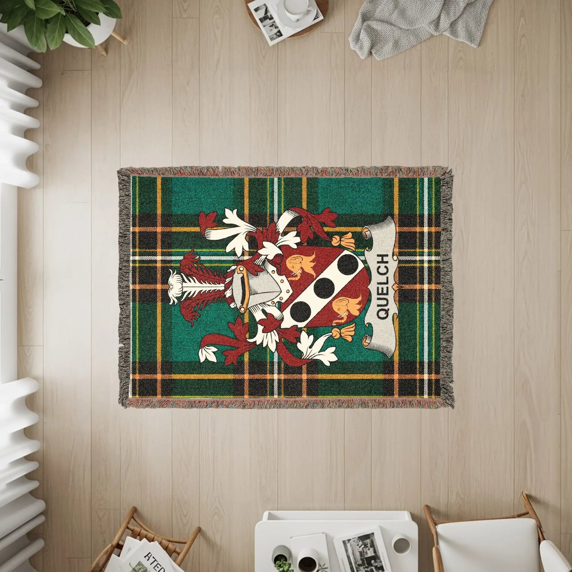 Woven blanket with green plaid and the Quelch family crest.