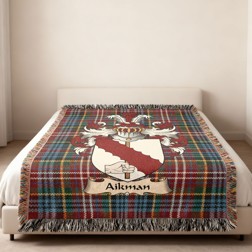 Aikman family crest emblem on a Caledonia tartan woven blanket
