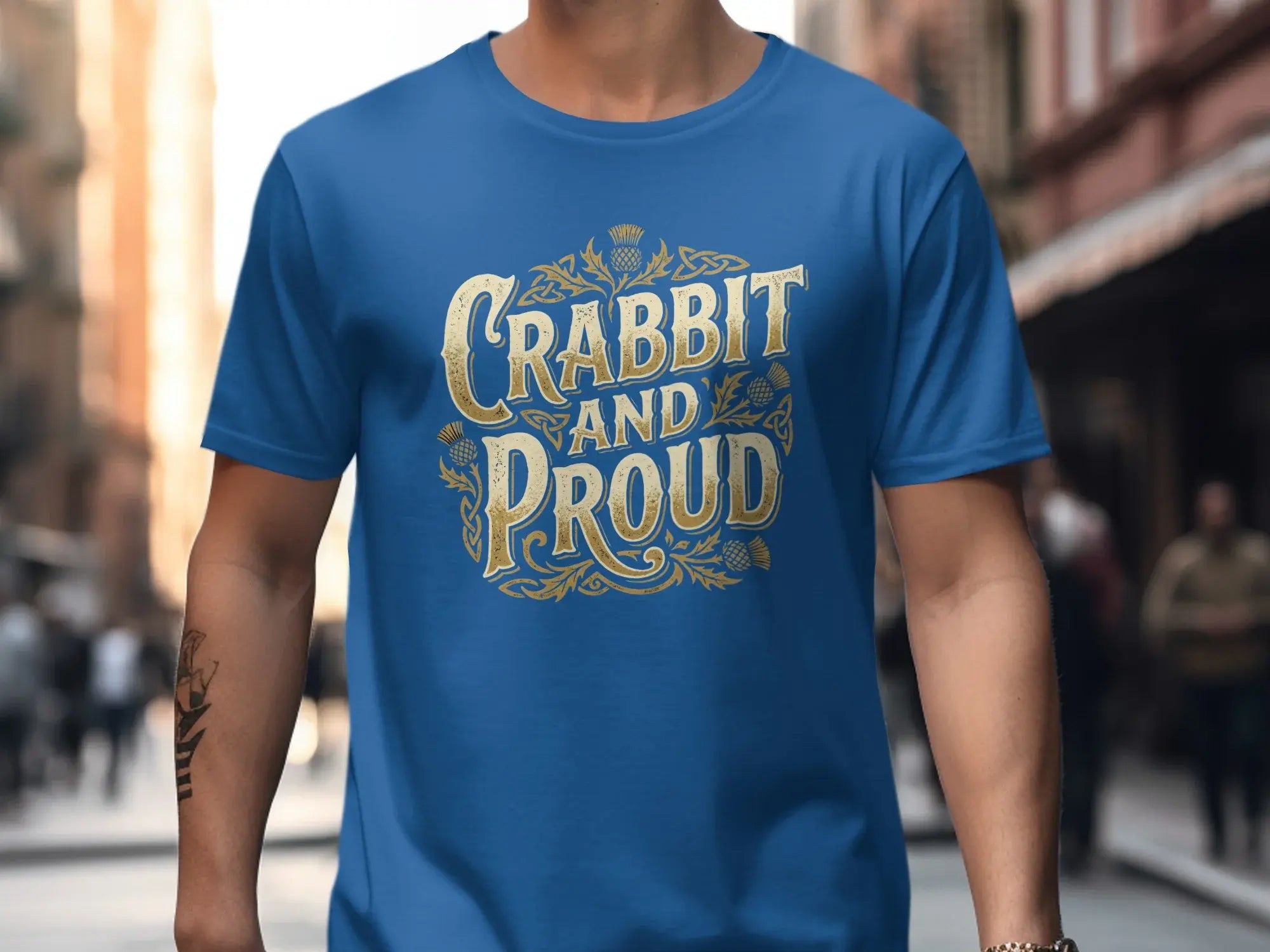 Blue t-shirt with gold Celtic knot design and "Crabbit and Proud" text.