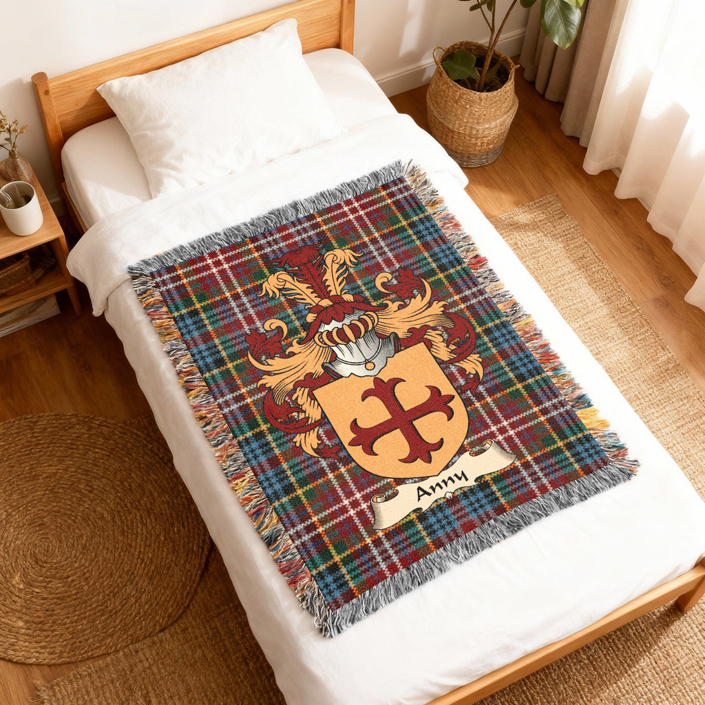 Anny Scottish family shield woven blanket with Caledonia tartan background, displayed on a bed