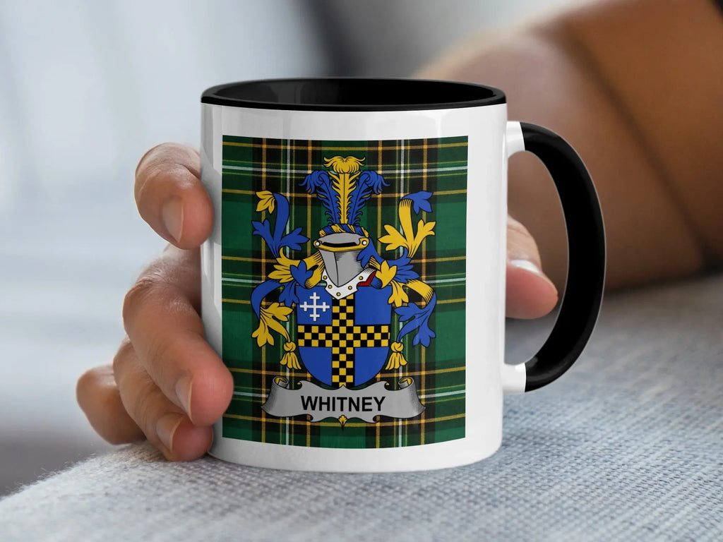 Mug with Whitney coat of arms and plaid pattern held in hand.